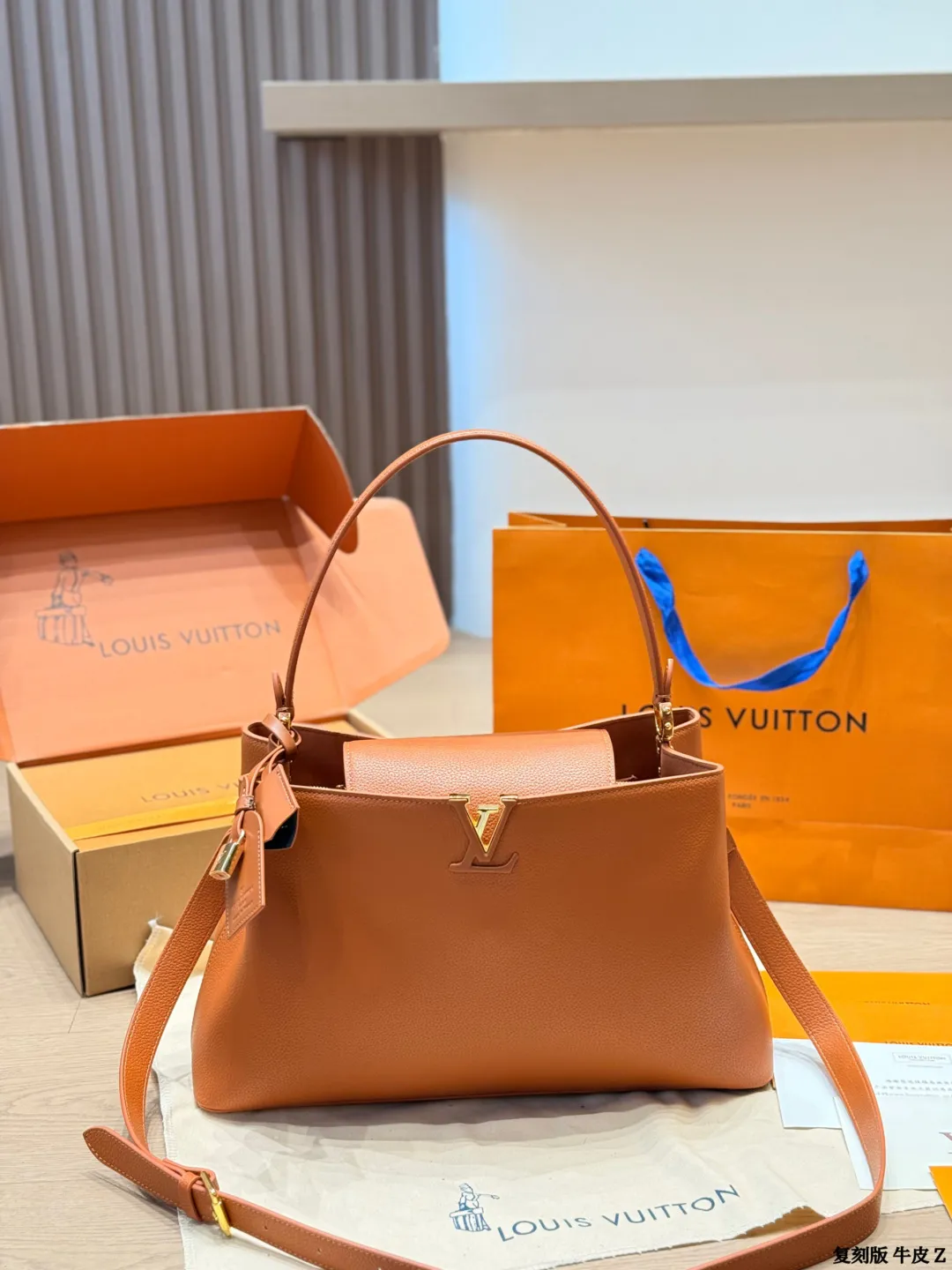 LV 1:1 premium Low Key Hobo bag in Cognac grained calfskin with gold-tone padlock and adjustable strap on display with boutique packaging - xiashuluxe