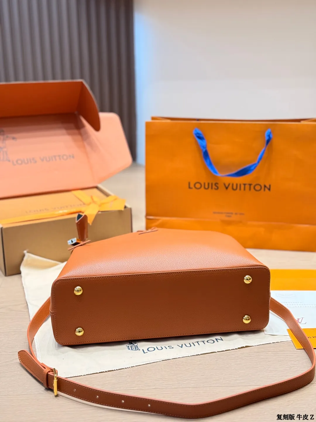 LV 1:1 premium Low Key Hobo bag in Cognac grained calfskin with gold-tone padlock and adjustable strap on display with boutique packaging - xiashuluxe