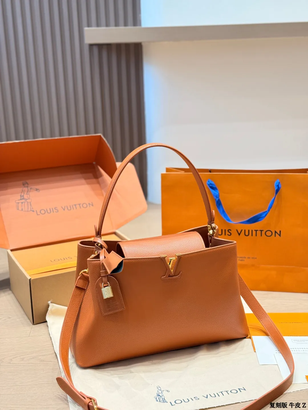 LV 1:1 premium Low Key Hobo bag in Cognac grained calfskin with gold-tone padlock and adjustable strap on display with boutique packaging - xiashuluxe