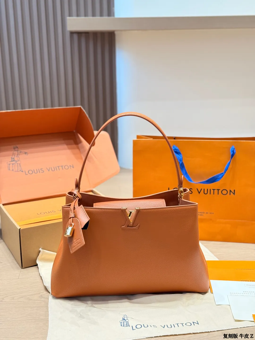 LV 1:1 premium Low Key Hobo bag in Cognac grained calfskin with gold-tone padlock and adjustable strap on display with boutique packaging - xiashuluxe