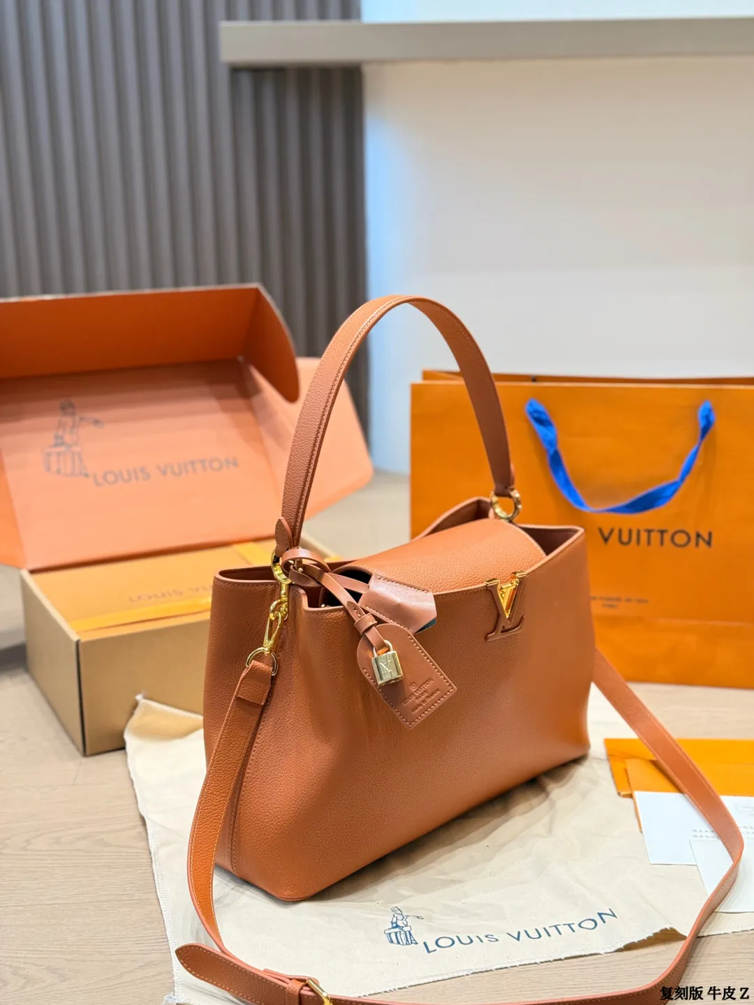 LV 1:1 premium Low Key Hobo bag in Cognac grained calfskin with gold-tone padlock and adjustable strap on display with boutique packaging - xiashuluxe