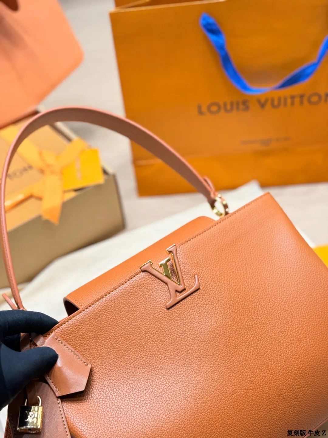 LV 1:1 premium Low Key Hobo bag in Cognac grained calfskin with gold-tone padlock and adjustable strap on display with boutique packaging - xiashuluxe