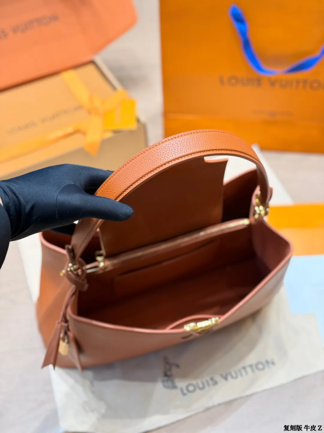 LV 1:1 premium Low Key Hobo bag in Cognac grained calfskin with gold-tone padlock and adjustable strap on display with boutique packaging - xiashuluxe