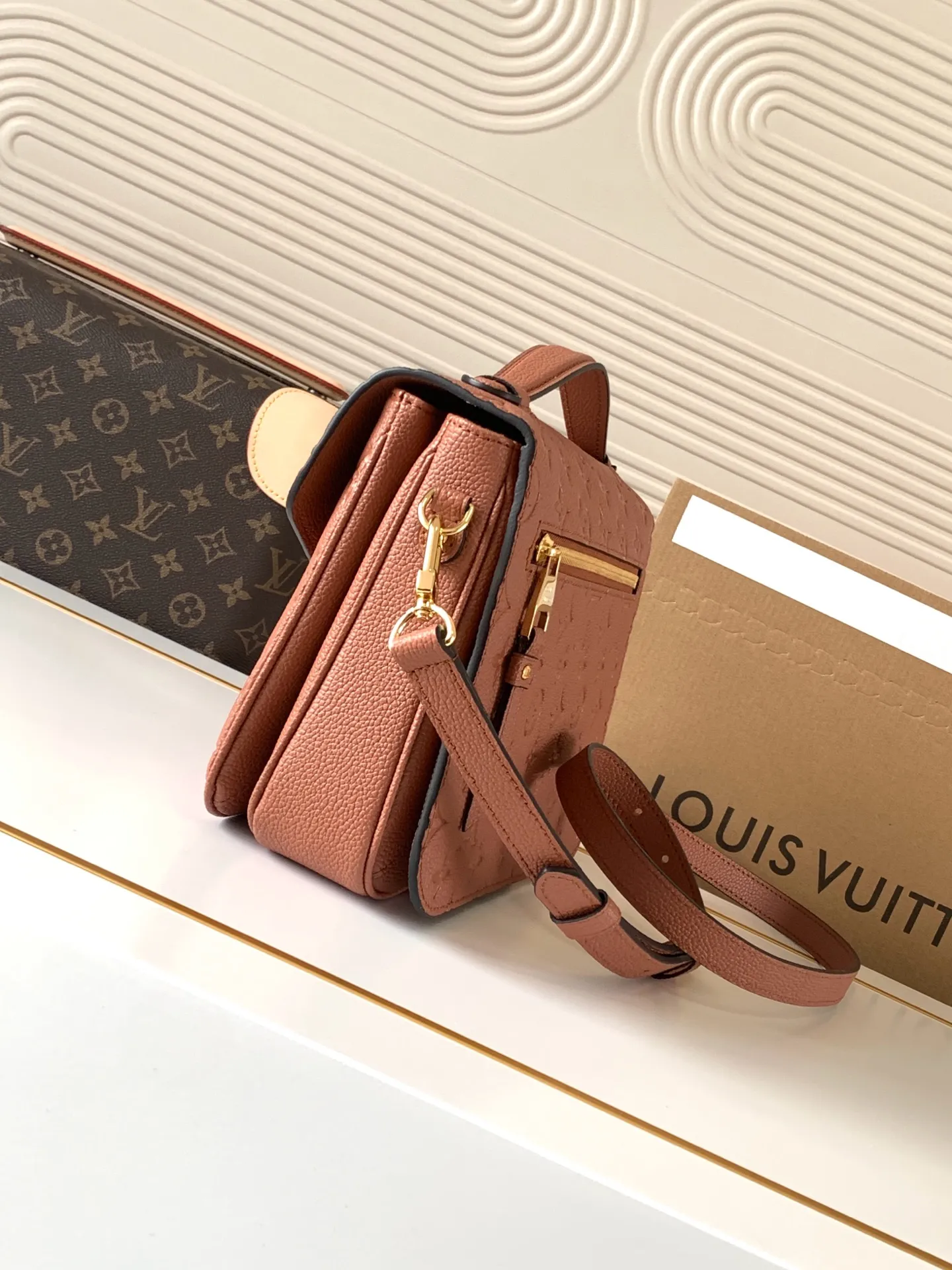 Detailed close-up of brown Empreinte leather embossing and neat edge painting on LV Metis bag