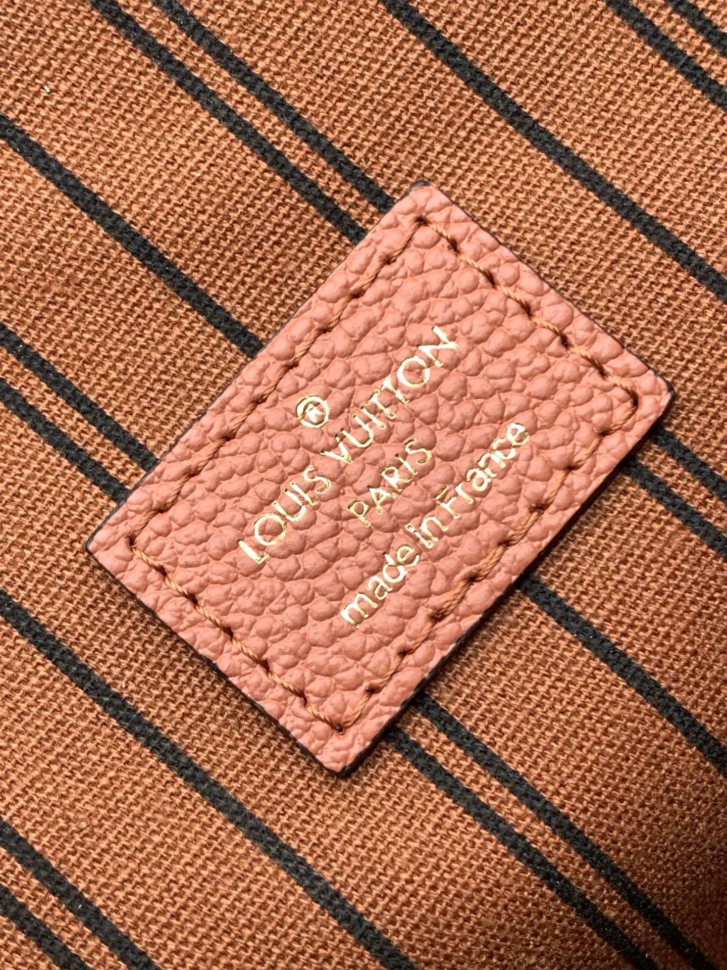 Full view of LV Pochette Metis in a professional studio setting with the orange LV gift box