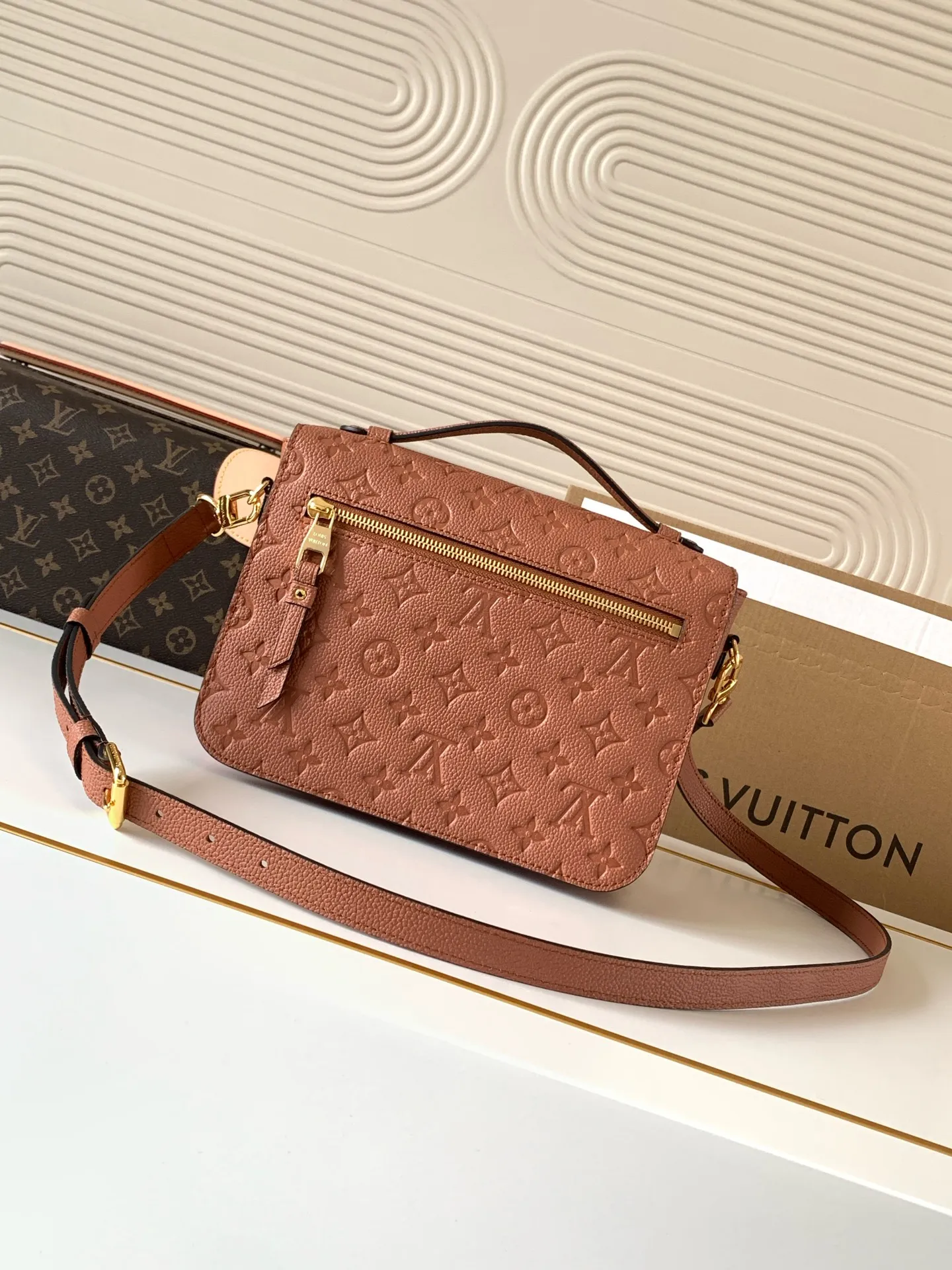 Side view showing structured shape and gusset design of LV Pochette Metis Empreinte bag