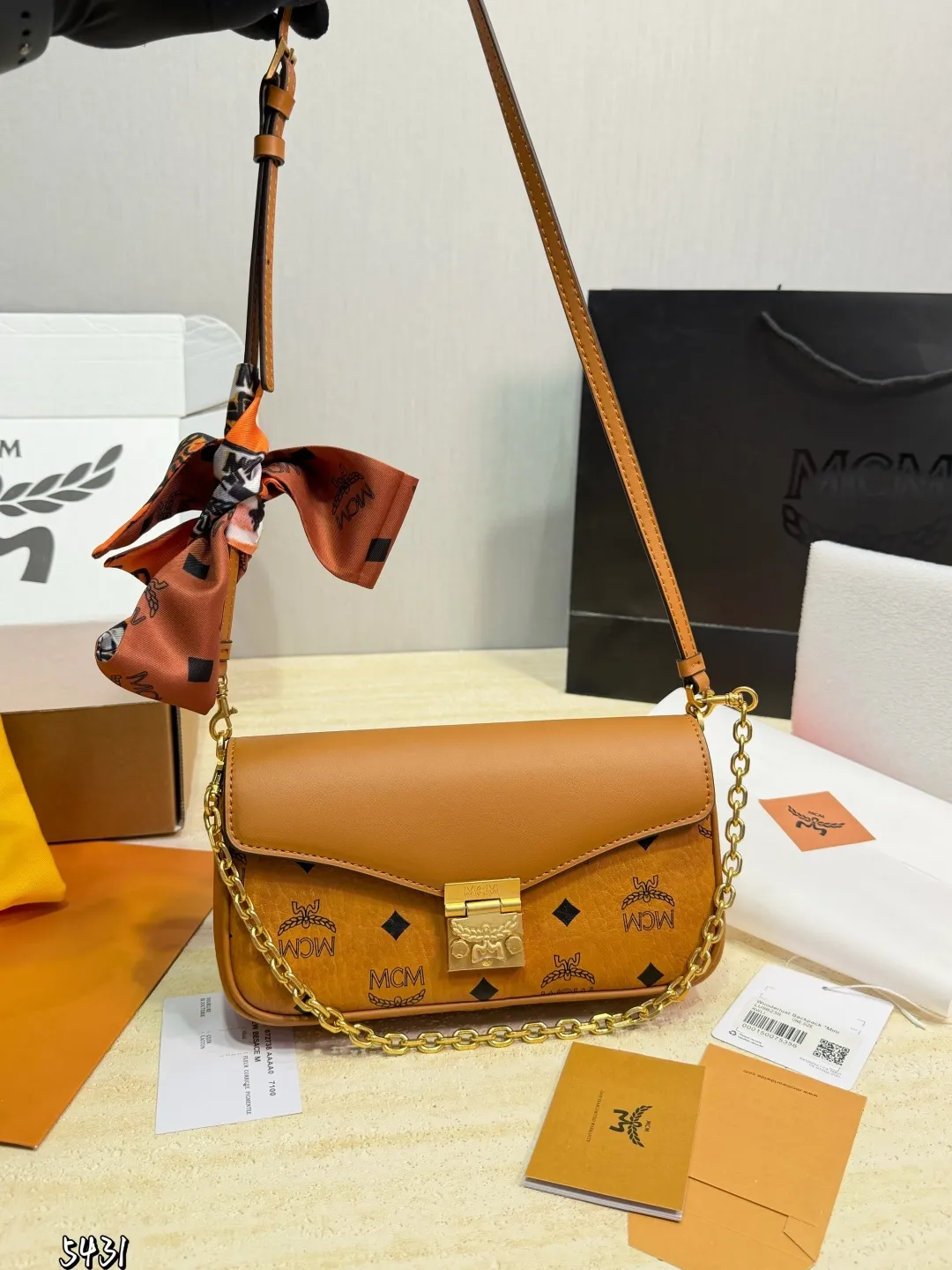 p155（飞机礼盒） MCM Tracy链条包 MCM Tracy链条包，干邑色Visetos老花+牛皮拼接，复古又时髦！金属月桂叶锁扣超有辦识度，肩带可调节，手拎、单肩、斜挎都OK，日常通勤or休闲出街都能轻松驾驭幽。内部有拉链隔层和卡槽，收纳手机、卡包超方便，实用又百搭，是轻奢包包热门之选！ 尺寸 20 11cm