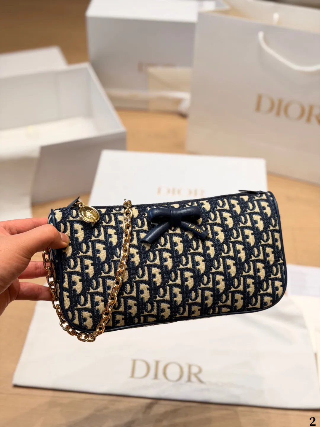p140 Dior Oblique蝴蝶结链条包​​ 💙Dior Oblique蝴蝶结链条包，经典蓝色老花帆布+黑色蝴蝶结，法式优雅又俏皮✨。金属链条肩带，手提、单肩、斜挎都OK，日常通勤或休闲出街都超百搭！尺寸适中，手机、化妆品轻松装下，拉链开合更安全🔒。Oblique老花图案辨识度超高，是Dior标志性设计，实用又时髦，轻松点亮你的穿搭风格🎀 尺寸 26cm