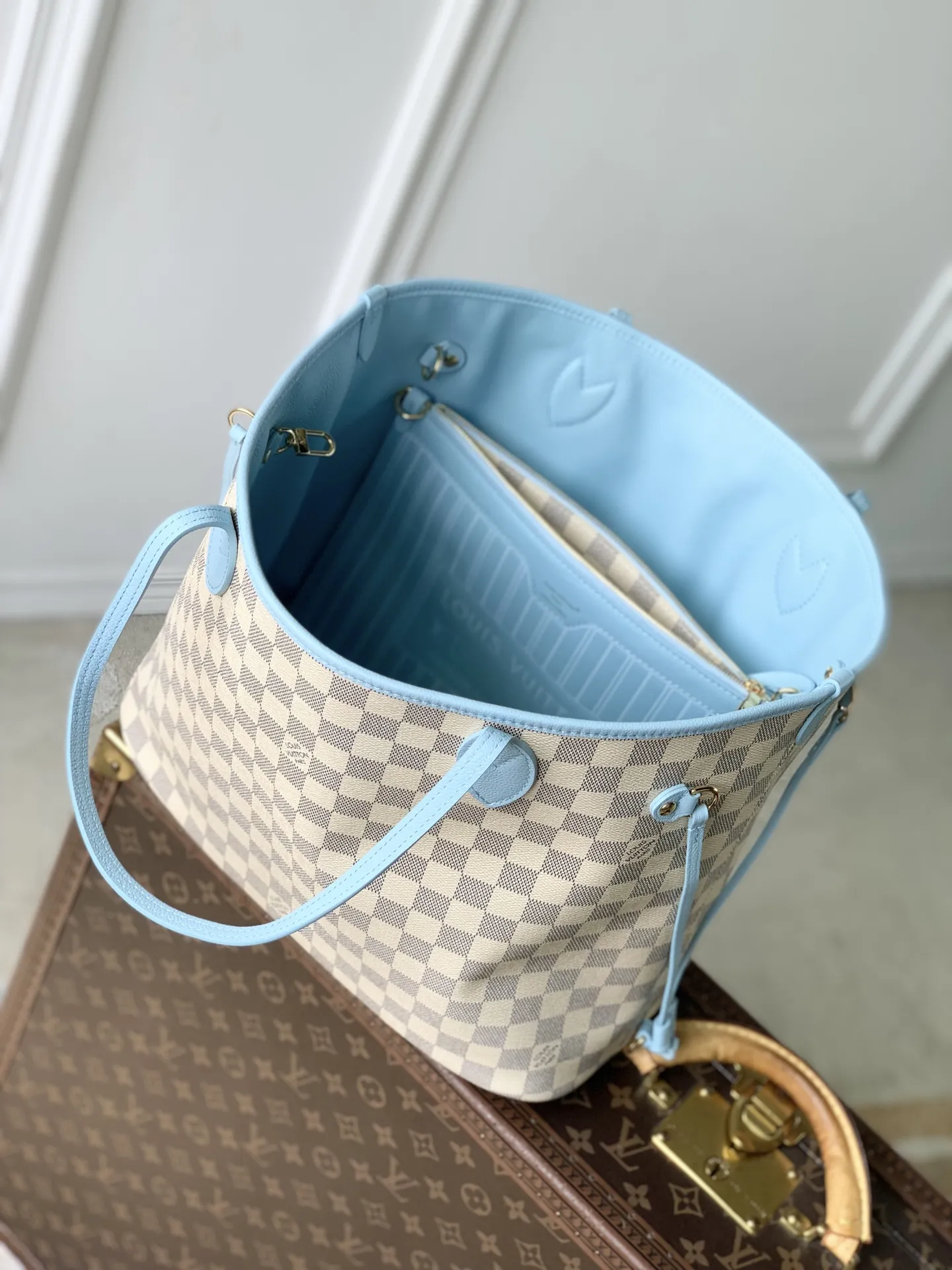 N40946白格蓝色 Damier Azur 标识以柔雅色彩新释，契合即将到来的温煦季节。本款 Neverfull Inside Out 中号手袋搭载路易威登拉链袋与莹泽金属件；侧面饰带与钩扣可灵活调节廓形。宽敞容量可轻松收纳笔记本电脑等日常物件。 47 x 28 x 14 厘米 (长度 x 高 x 宽)