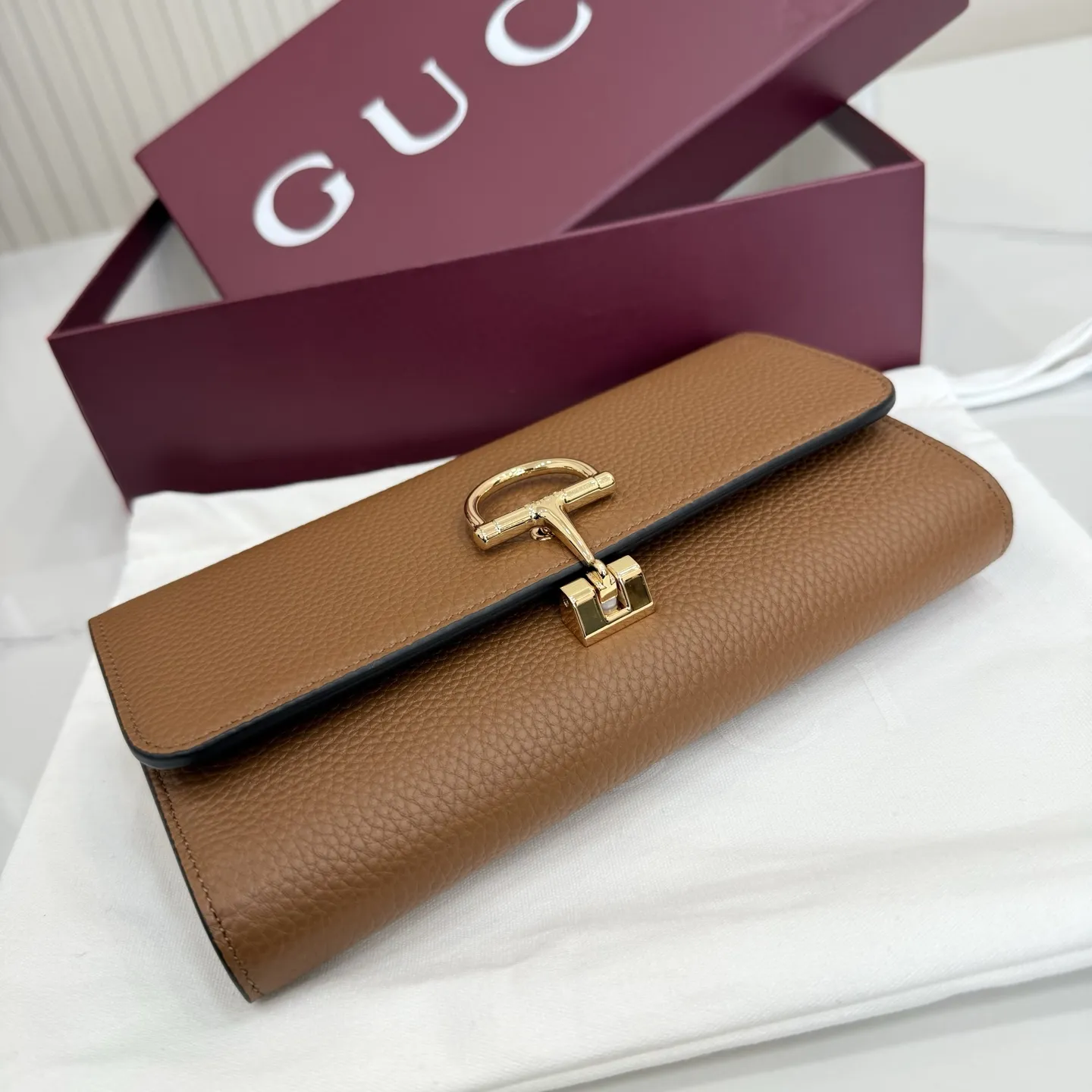 p270。【配全套包装】‼️品牌以当代视角演绎标志性元素,焕新呈现Gucci半马衔扣设计,选用柔软牛皮革为经典配件注入新意风尚。这款长款钱包以粒面软皮匠心打造,侧面饰有半马衔扣细节。 型号:848791。 闭合时尺寸:19厘米(宽)x 10厘米(高)x 3.5厘米(深); 打开时尺寸:19厘米(宽)x 18厘米(高) 重量:约230克 颜色:棕色/全皮