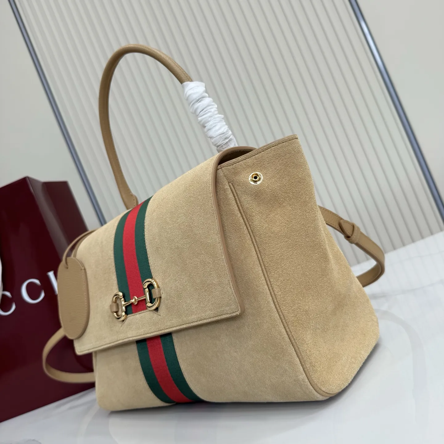 p710。【配全套包装】‼️Generation Gucci古驰世代系列深入探索品牌的典藏元素,将不同世代的设计融合为统一的美学叙事。这款款式以手提包设计向品牌标志性的马衔扣元素致敬,柔软的绒面皮革呈现精致的配色。 沙色柔软绒面材质 沙色皮革滚边 金色调配件 沙色帆布衬里,饰Diamante图案 马衔扣、织带和皮革标牌,带有“Made in Italy Gucci”标志 饰按扣 内部:1个拉链口袋,1个开口口袋 手柄垂直高度:17厘米 可拆卸和可调节皮革肩带下垂长度:42 - 54厘米;长度:93 - 112厘米 磁扣开合 型号:875018。 尺寸:30厘米(宽)x 21厘米(高)x 12厘米(深) 重量:约685克 颜色:杏色/绒皮。 意大利创作