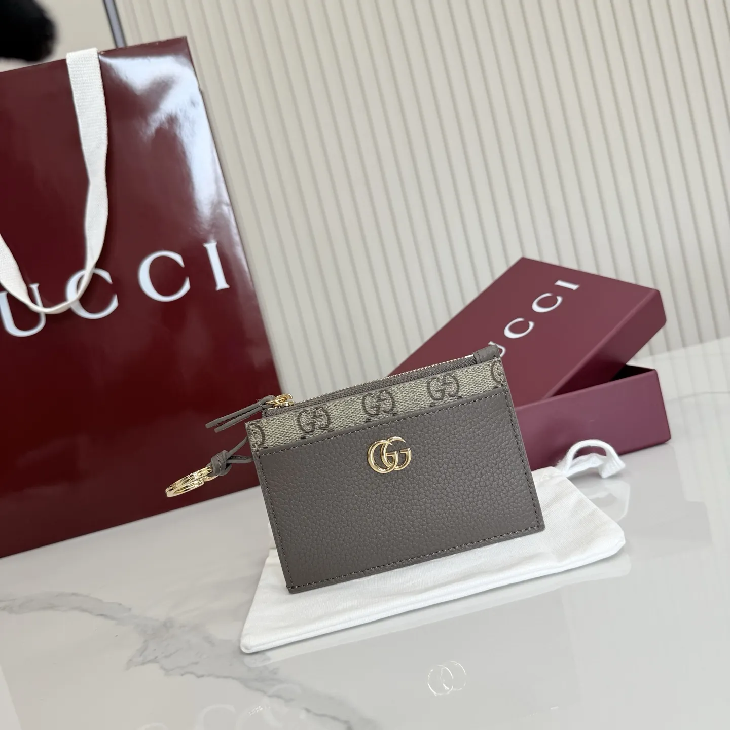 p160。【配全套包装】‼️Generation Gucci 系列深入探索品牌典藏元素,将不同年代的设计融合于一体,呈现出独特的美学叙事。GG Marmont 系列包含双色款式,如这款配有标志性双G造型配件的拉链钥匙包。 深灰褐色皮革 沙色和深棕色GG Supreme帆布滚边 金色调配件 深灰褐色塔夫绸衬里 双G 钥匙扣钩 内部:2个平底口袋,1个拉链口袋,4个卡片隔层 拉链开合 重量:约0.066千克 型号:837966。 尺寸:12厘米(宽)x 8.5厘米(高) 颜色:啡深灰褐色。 意大利创作