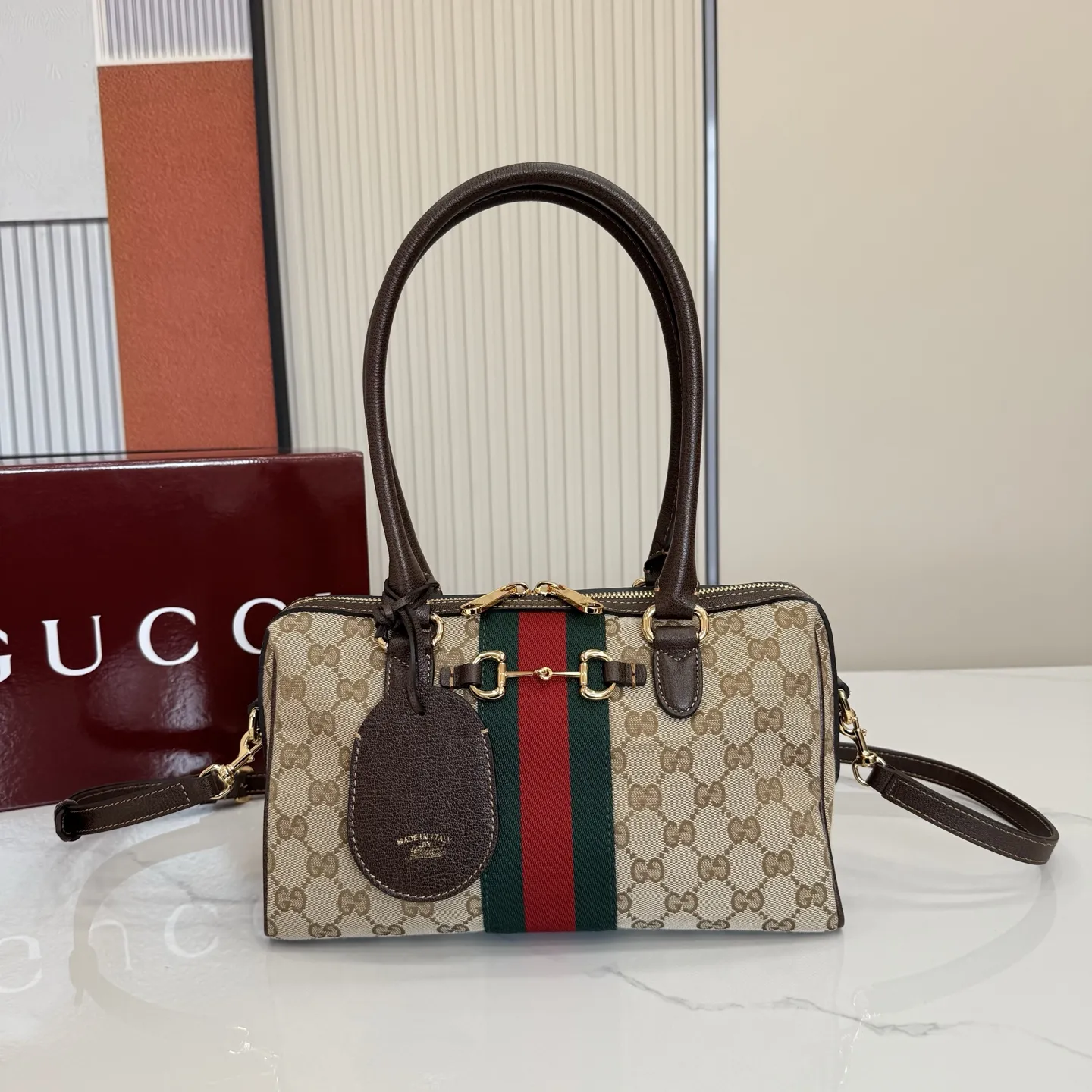 p640。【配全套专柜包装】‼️2026春夏系列全新上市。Gucci Borsetto系列名称巧妙融合意大利语&ldquo;borsa&rdquo;（手袋）和&ldquo;morsetto&rdquo;（马衔扣）二词。 这款手袋甄选轻盈挺括的GG帆布打造，以复古风格沙色配色匠心呈献，源自典藏的钻石菱格纹图案演绎全新衬里。 沙色和深棕色GG帆布 深棕色软皮皮革滚边 金色调配件 米色帆布衬里饰钻石菱格纹图案 Horsebit、Web和皮革标签，带有&ldquo;Made in Italy by Gucci&rdquo;标志 手柄高：20cm 可拆卸和可调节的皮革肩带，高：44 - 50厘米；长度：100 - 115厘米 双拉链开合 型号：866732。 尺寸：28厘米（宽）x 15厘米（高）x 10厘米（深） 重量：约0.5千克 颜色：杏布/棕色。 意大利创作