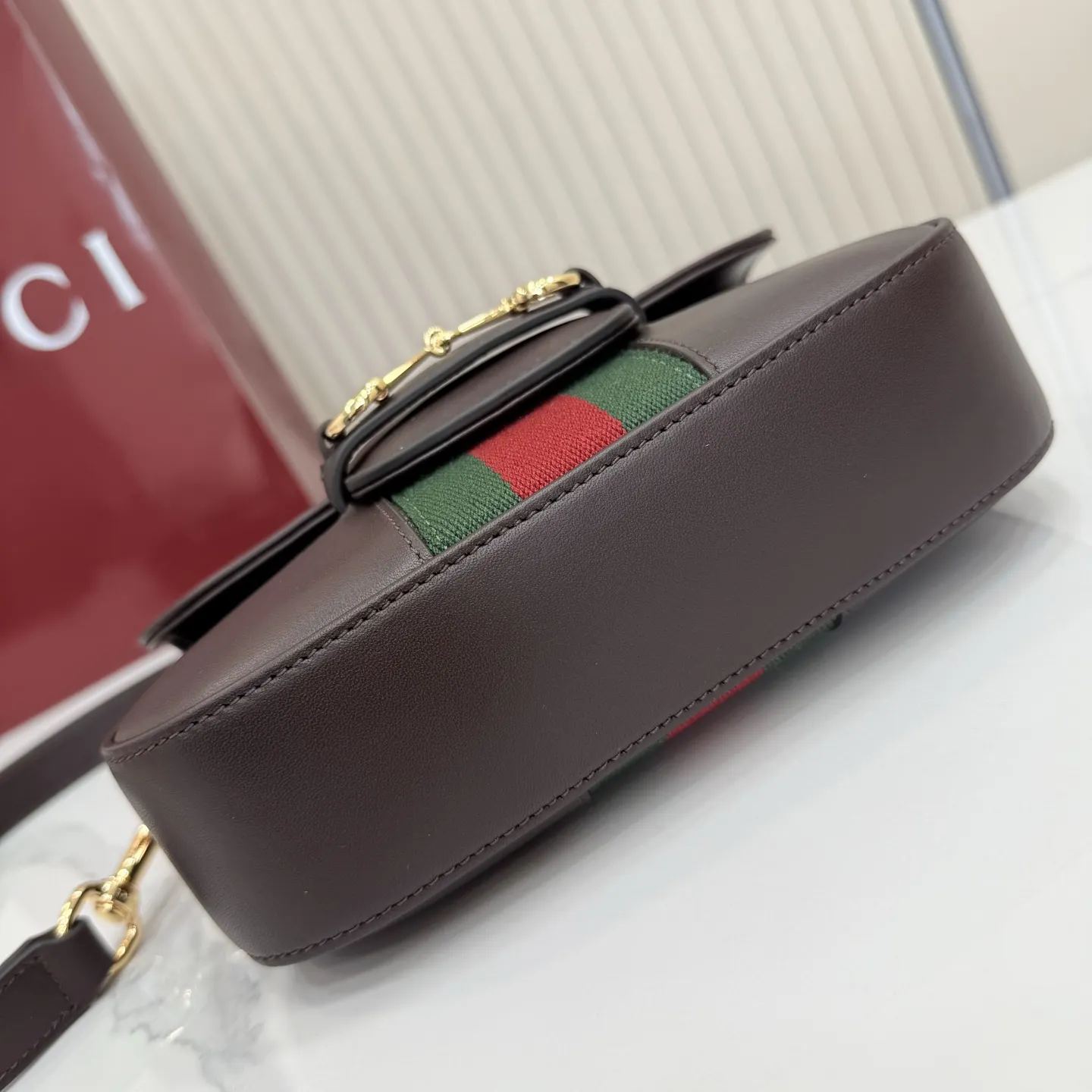 p660。【配全套专柜包装】‼️2026春夏系列全新上市。Gucci Horsebit 1955 系列包袋呈现柔韧雅致的廓形。此款式甄选柔软牛皮革打造，饰有Web织带细节，另配一条简约的可调节牛皮革肩带。 深棕色软皮 金色调配件 米色帆布衬里饰钻石菱格纹图案 马衔扣和织带 可拆卸和可调节牛皮革肩带，配搭扣，高：30厘米 翻盖开合 型号：866762。 尺寸：21厘米（宽）x 14.5厘米（高）x 5.5厘米（深） 重量：约0.5千克 颜色：深棕色/全皮。 意大利创作