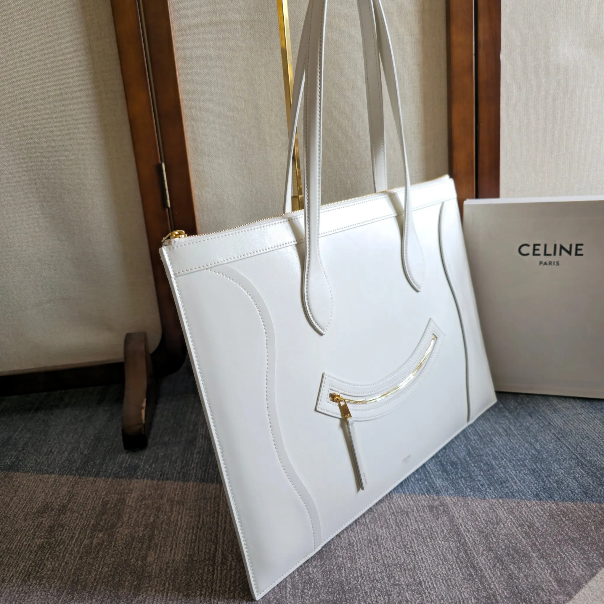新品上线🅰️🅰️ 2026年春夏新款笑脸包. 十几年前的 It Bag，Ce 笑脸包回归啦&hellip;&hellip; Ce26春夏大秀，Michael Rider 将10年诞生、红极一时的&ldquo;笑脸包&rdquo;带回大众视野。 除了廓形变得更加窄长、囧脸变笑脸以外，还推出了超薄造型的 Flat Cabas 笑脸包。秀款中还有许多不同Size、配色亟待推出✅ 款号：123963 颜色：白色 44.5x31.5x0.5cm：44.5x31.5x0.5cm