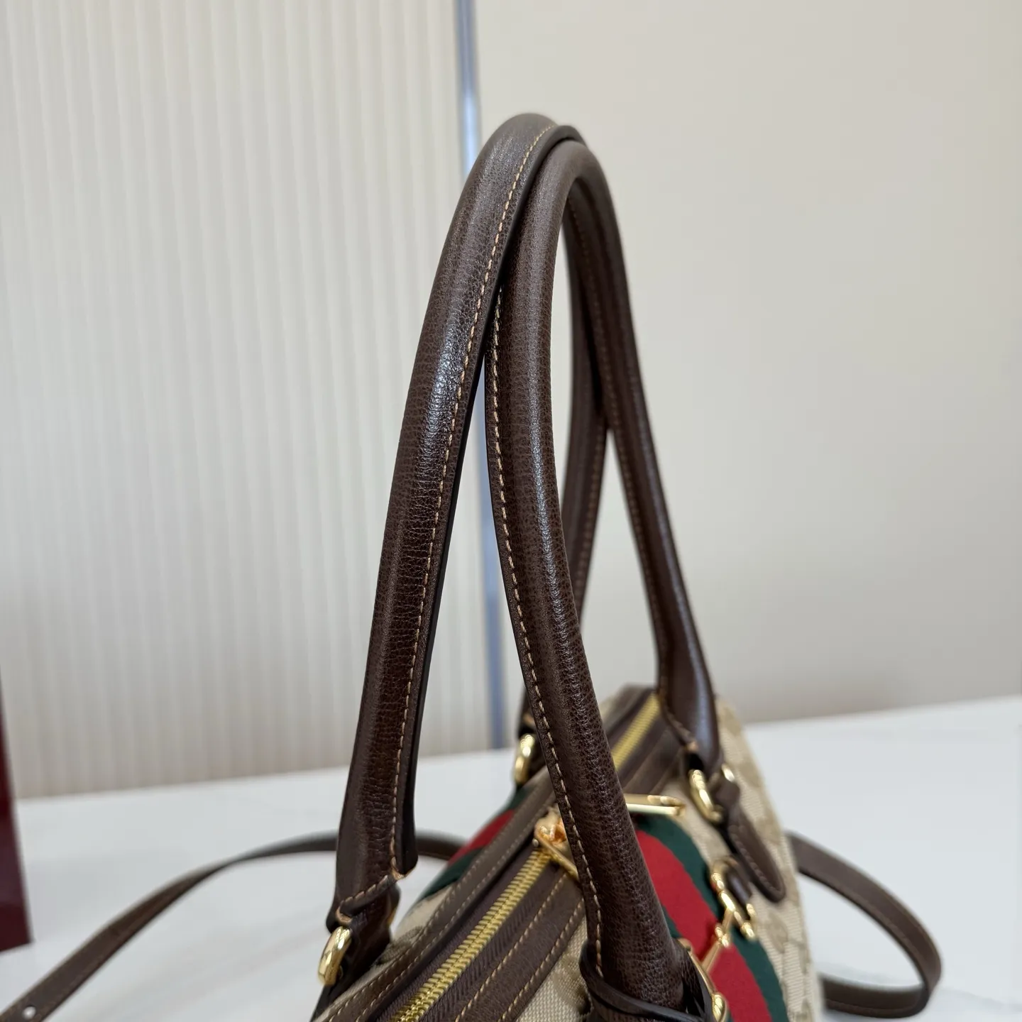 p640。【配全套专柜包装】‼️2026春夏系列全新上市。Gucci Borsetto系列名称巧妙融合意大利语&ldquo;borsa&rdquo;（手袋）和&ldquo;morsetto&rdquo;（马衔扣）二词。 这款手袋甄选轻盈挺括的GG帆布打造，以复古风格沙色配色匠心呈献，源自典藏的钻石菱格纹图案演绎全新衬里。 沙色和深棕色GG帆布 深棕色软皮皮革滚边 金色调配件 米色帆布衬里饰钻石菱格纹图案 Horsebit、Web和皮革标签，带有&ldquo;Made in Italy by Gucci&rdquo;标志 手柄高：20cm 可拆卸和可调节的皮革肩带，高：44 - 50厘米；长度：100 - 115厘米 双拉链开合 型号：866732。 尺寸：28厘米（宽）x 15厘米（高）x 10厘米（深） 重量：约0.5千克 颜色：杏布/棕色。 意大利创作