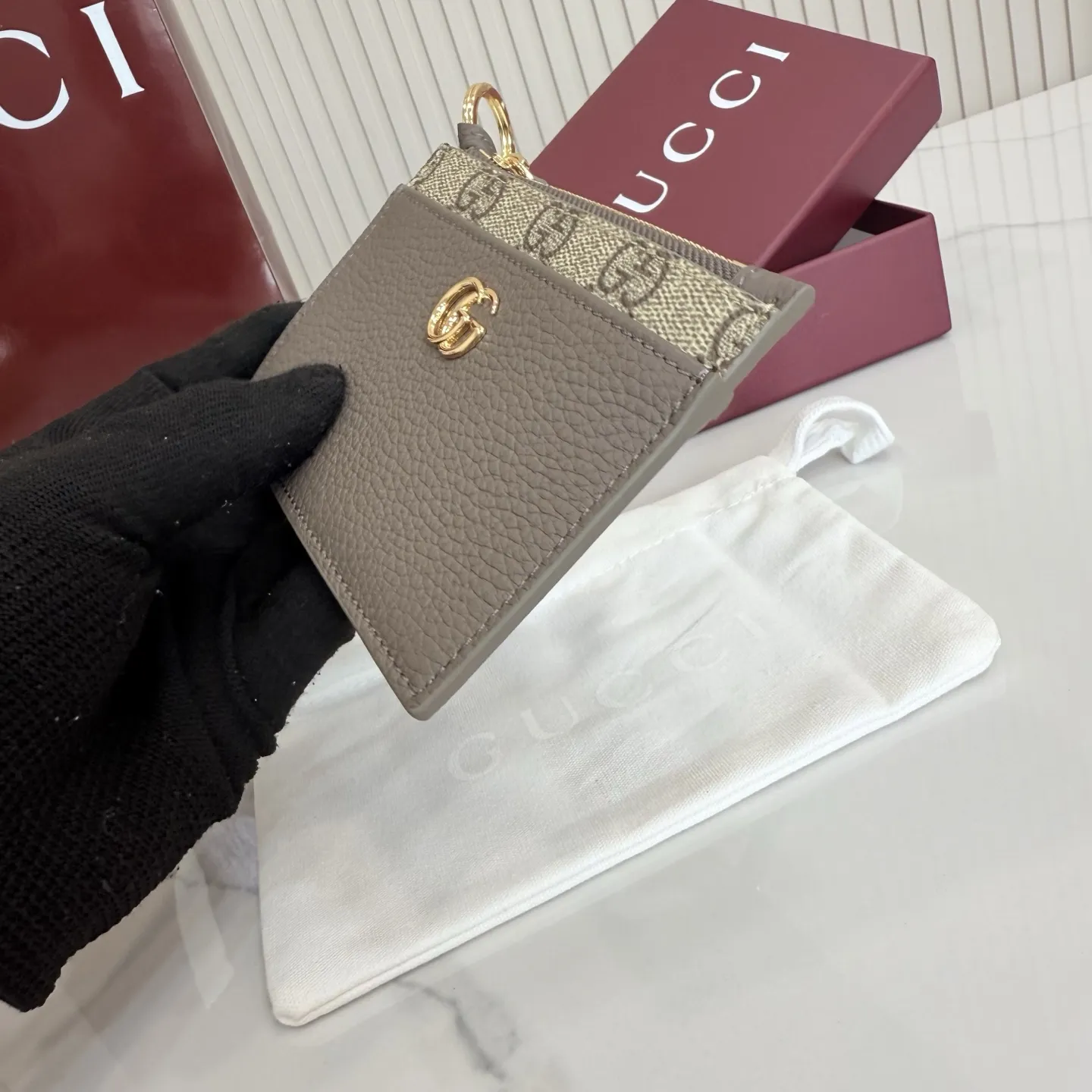p160。【配全套包装】‼️Generation Gucci 系列深入探索品牌典藏元素,将不同年代的设计融合于一体,呈现出独特的美学叙事。GG Marmont 系列包含双色款式,如这款配有标志性双G造型配件的拉链钥匙包。 深灰褐色皮革 沙色和深棕色GG Supreme帆布滚边 金色调配件 深灰褐色塔夫绸衬里 双G 钥匙扣钩 内部:2个平底口袋,1个拉链口袋,4个卡片隔层 拉链开合 重量:约0.066千克 型号:837966。 尺寸:12厘米(宽)x 8.5厘米(高) 颜色:啡深灰褐色。 意大利创作