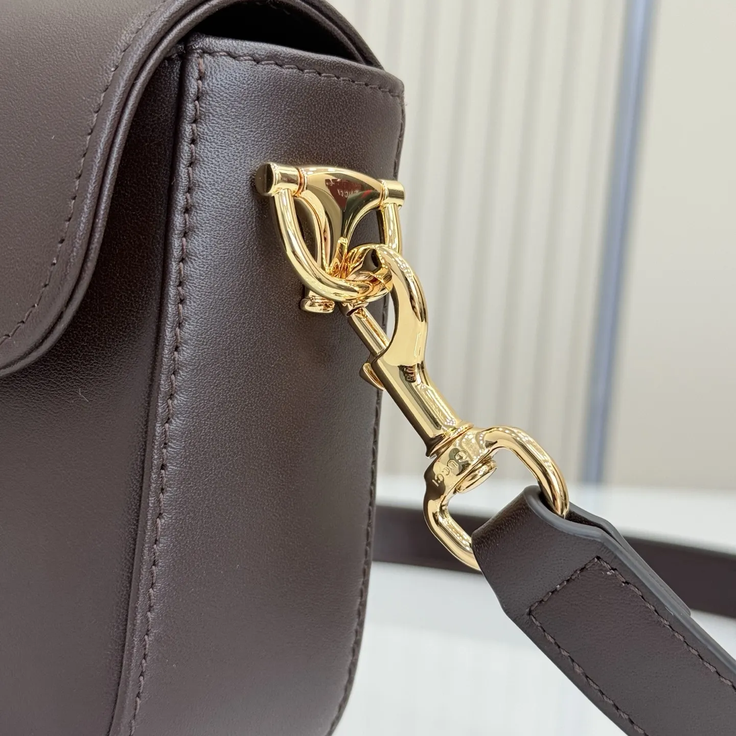 p660。【配全套专柜包装】‼️2026春夏系列全新上市。Gucci Horsebit 1955 系列包袋呈现柔韧雅致的廓形。此款式甄选柔软牛皮革打造,饰有Web织带细节,另配一条简约的可调节牛皮革肩带。 深棕色软皮 金色调配件 米色帆布衬里饰钻石菱格纹图案 马衔扣和织带 可拆卸和可调节牛皮革肩带,配搭扣,高:30厘米 翻盖开合 型号:866762。 尺寸:21厘米(宽)x 14.5厘米(高)x 5.5厘米(深) 重量:约0.5千克 颜色:深棕色/全皮。 意大利创作