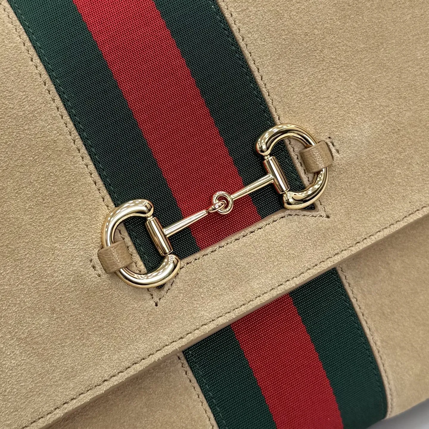 p710。【配全套包装】‼️Generation Gucci古驰世代系列深入探索品牌的典藏元素,将不同世代的设计融合为统一的美学叙事。这款款式以手提包设计向品牌标志性的马衔扣元素致敬,柔软的绒面皮革呈现精致的配色。 沙色柔软绒面材质 沙色皮革滚边 金色调配件 沙色帆布衬里,饰Diamante图案 马衔扣、织带和皮革标牌,带有“Made in Italy Gucci”标志 饰按扣 内部:1个拉链口袋,1个开口口袋 手柄垂直高度:17厘米 可拆卸和可调节皮革肩带下垂长度:42 - 54厘米;长度:93 - 112厘米 磁扣开合 型号:875018。 尺寸:30厘米(宽)x 21厘米(高)x 12厘米(深) 重量:约685克 颜色:杏色/绒皮。 意大利创作