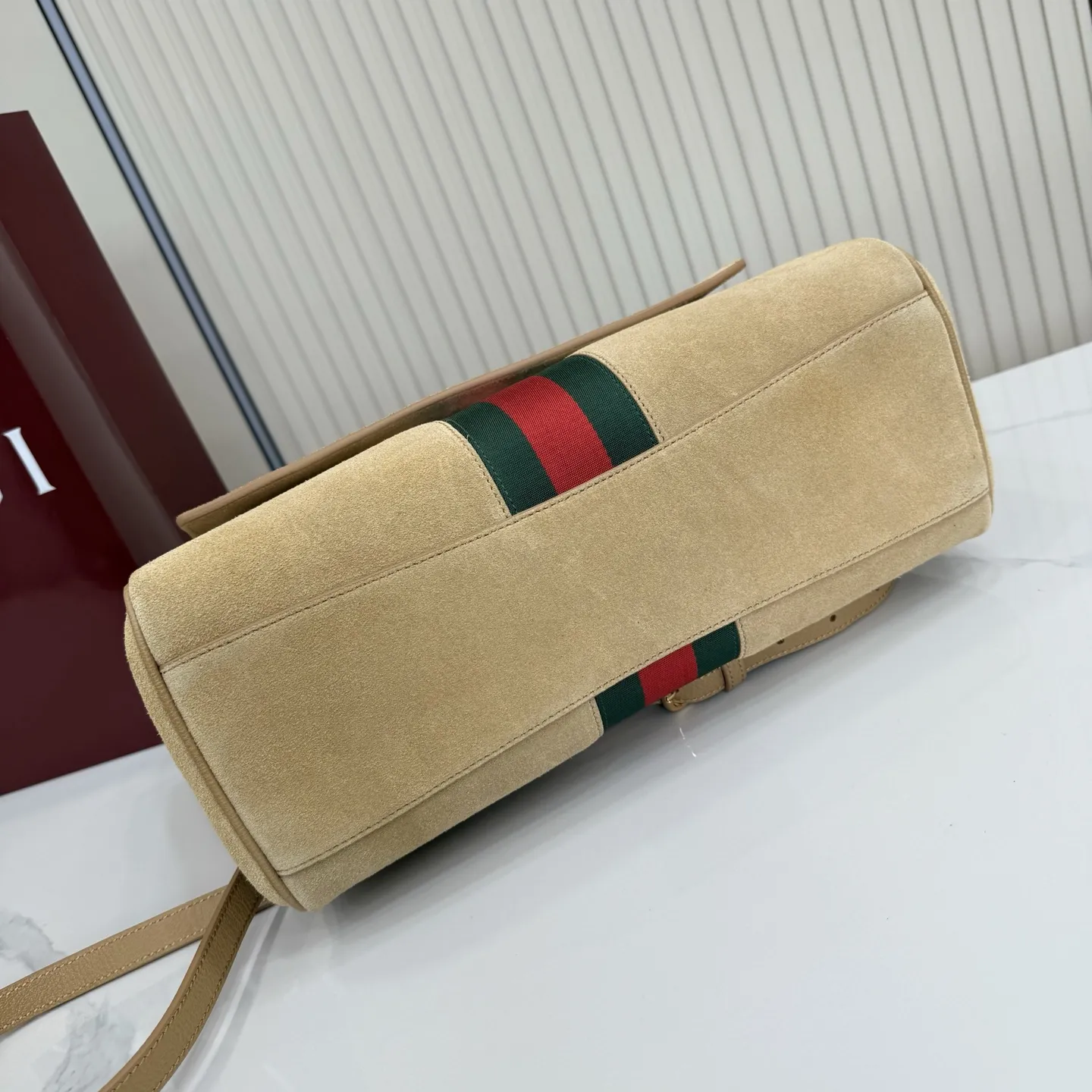 p710。【配全套包装】‼️Generation Gucci古驰世代系列深入探索品牌的典藏元素，将不同世代的设计融合为统一的美学叙事。这款款式以手提包设计向品牌标志性的马衔扣元素致敬，柔软的绒面皮革呈现精致的配色。 沙色柔软绒面材质 沙色皮革滚边 金色调配件 沙色帆布衬里，饰Diamante图案 马衔扣、织带和皮革标牌，带有&ldquo;Made in Italy Gucci&rdquo;标志 饰按扣 内部：1个拉链口袋，1个开口口袋 手柄垂直高度：17厘米 可拆卸和可调节皮革肩带下垂长度：42 - 54厘米；长度：93 - 112厘米 磁扣开合 型号：875018。 尺寸：30厘米（宽）x 21厘米（高）x 12厘米（深） 重量：约685克 颜色：杏色/绒皮。 意大利创作