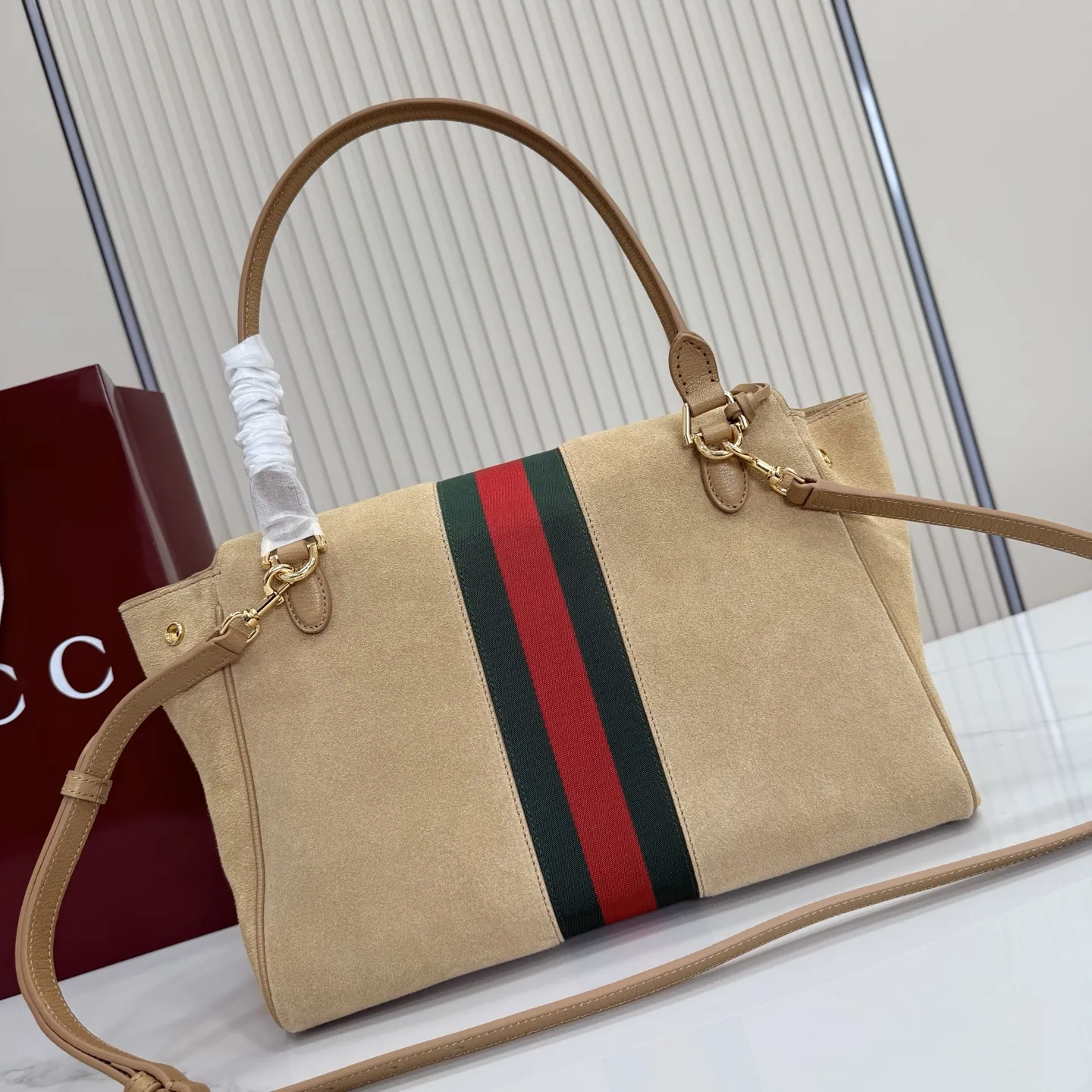 p710。【配全套包装】‼️Generation Gucci古驰世代系列深入探索品牌的典藏元素，将不同世代的设计融合为统一的美学叙事。这款款式以手提包设计向品牌标志性的马衔扣元素致敬，柔软的绒面皮革呈现精致的配色。 沙色柔软绒面材质 沙色皮革滚边 金色调配件 沙色帆布衬里，饰Diamante图案 马衔扣、织带和皮革标牌，带有&ldquo;Made in Italy Gucci&rdquo;标志 饰按扣 内部：1个拉链口袋，1个开口口袋 手柄垂直高度：17厘米 可拆卸和可调节皮革肩带下垂长度：42 - 54厘米；长度：93 - 112厘米 磁扣开合 型号：875018。 尺寸：30厘米（宽）x 21厘米（高）x 12厘米（深） 重量：约685克 颜色：杏色/绒皮。 意大利创作