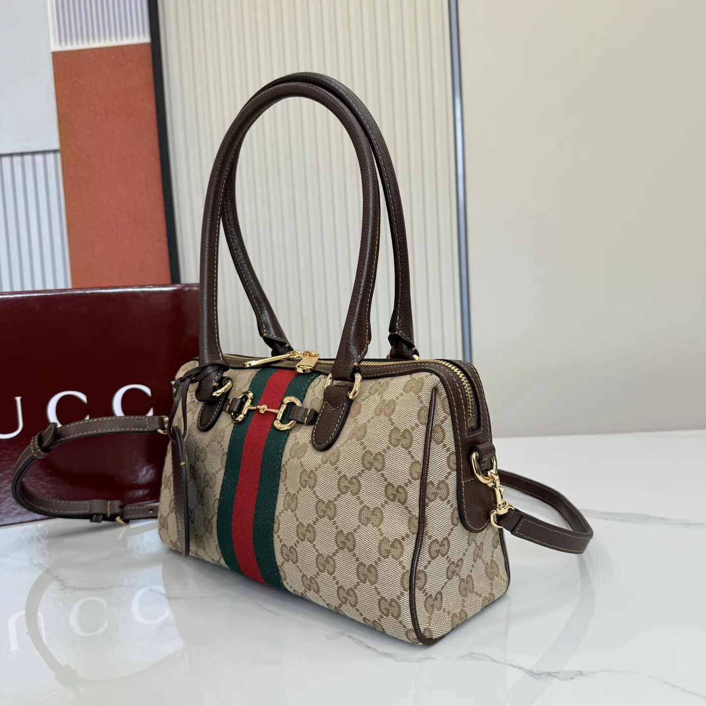 p640。【配全套专柜包装】‼️2026春夏系列全新上市。Gucci Borsetto系列名称巧妙融合意大利语&ldquo;borsa&rdquo;（手袋）和&ldquo;morsetto&rdquo;（马衔扣）二词。 这款手袋甄选轻盈挺括的GG帆布打造，以复古风格沙色配色匠心呈献，源自典藏的钻石菱格纹图案演绎全新衬里。 沙色和深棕色GG帆布 深棕色软皮皮革滚边 金色调配件 米色帆布衬里饰钻石菱格纹图案 Horsebit、Web和皮革标签，带有&ldquo;Made in Italy by Gucci&rdquo;标志 手柄高：20cm 可拆卸和可调节的皮革肩带，高：44 - 50厘米；长度：100 - 115厘米 双拉链开合 型号：866732。 尺寸：28厘米（宽）x 15厘米（高）x 10厘米（深） 重量：约0.5千克 颜色：杏布/棕色。 意大利创作