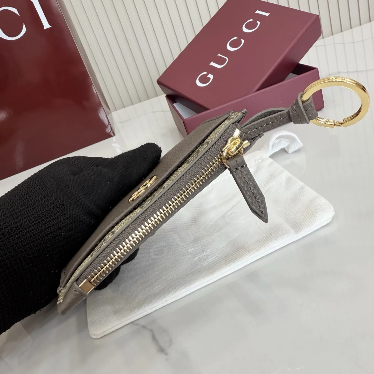 p160。【配全套包装】‼️Generation Gucci 系列深入探索品牌典藏元素,将不同年代的设计融合于一体,呈现出独特的美学叙事。GG Marmont 系列包含双色款式,如这款配有标志性双G造型配件的拉链钥匙包。 深灰褐色皮革 沙色和深棕色GG Supreme帆布滚边 金色调配件 深灰褐色塔夫绸衬里 双G 钥匙扣钩 内部:2个平底口袋,1个拉链口袋,4个卡片隔层 拉链开合 重量:约0.066千克 型号:837966。 尺寸:12厘米(宽)x 8.5厘米(高) 颜色:啡深灰褐色。 意大利创作
