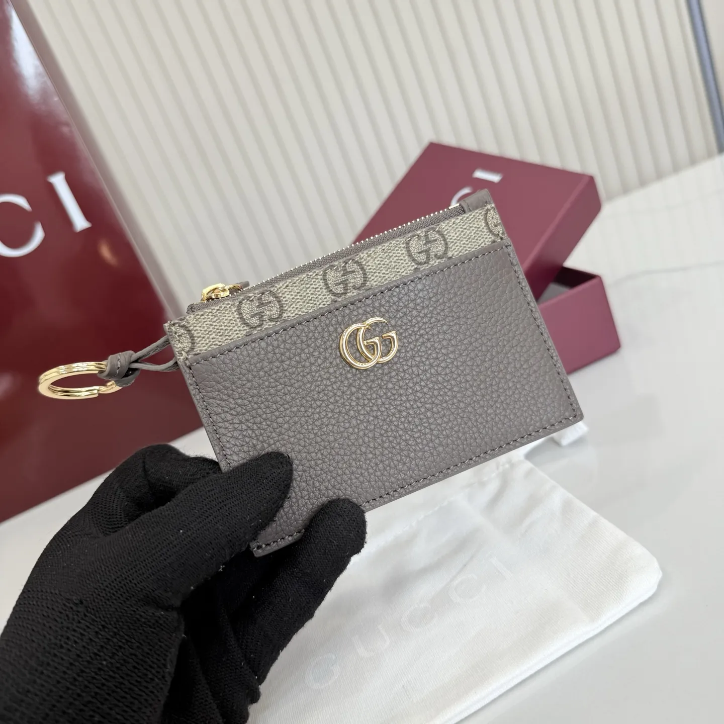 p160。【配全套包装】‼️Generation Gucci 系列深入探索品牌典藏元素,将不同年代的设计融合于一体,呈现出独特的美学叙事。GG Marmont 系列包含双色款式,如这款配有标志性双G造型配件的拉链钥匙包。 深灰褐色皮革 沙色和深棕色GG Supreme帆布滚边 金色调配件 深灰褐色塔夫绸衬里 双G 钥匙扣钩 内部:2个平底口袋,1个拉链口袋,4个卡片隔层 拉链开合 重量:约0.066千克 型号:837966。 尺寸:12厘米(宽)x 8.5厘米(高) 颜色:啡深灰褐色。 意大利创作