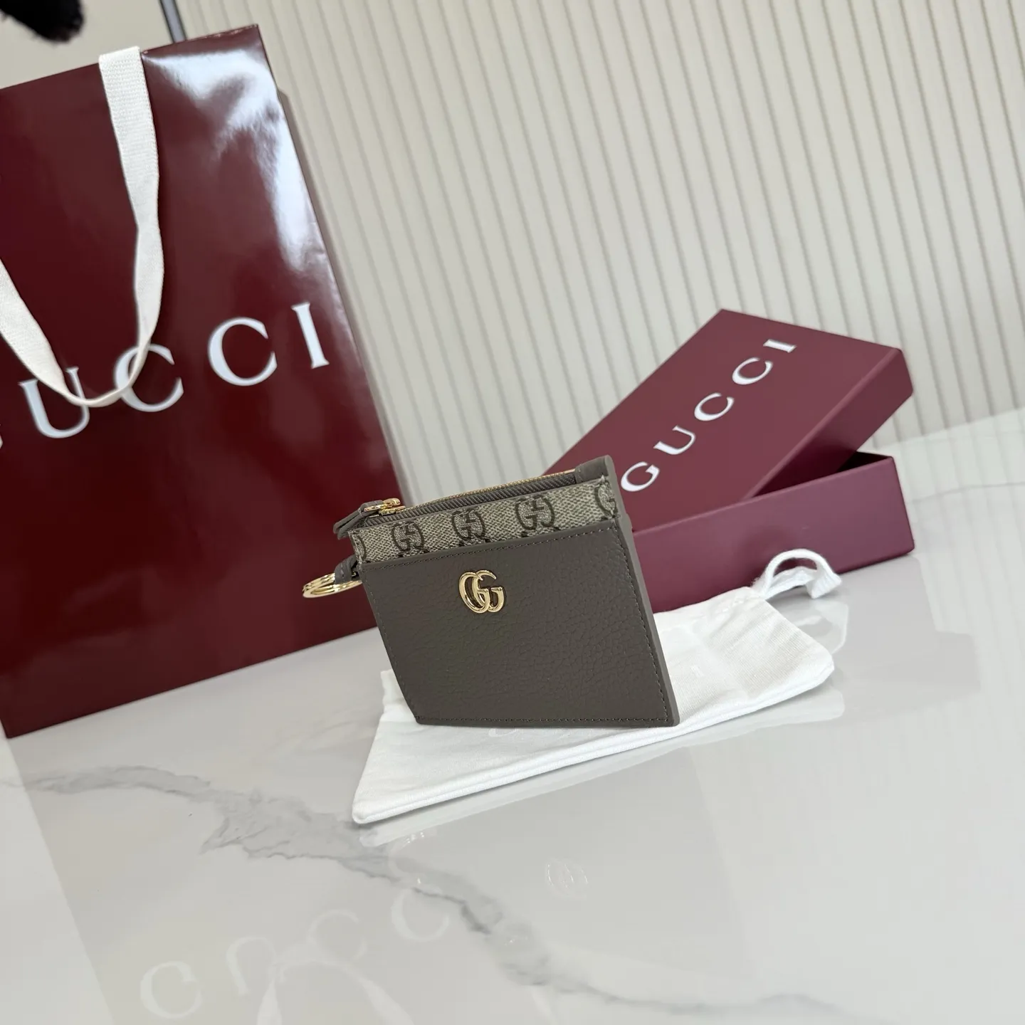 p160。【配全套包装】‼️Generation Gucci 系列深入探索品牌典藏元素,将不同年代的设计融合于一体,呈现出独特的美学叙事。GG Marmont 系列包含双色款式,如这款配有标志性双G造型配件的拉链钥匙包。 深灰褐色皮革 沙色和深棕色GG Supreme帆布滚边 金色调配件 深灰褐色塔夫绸衬里 双G 钥匙扣钩 内部:2个平底口袋,1个拉链口袋,4个卡片隔层 拉链开合 重量:约0.066千克 型号:837966。 尺寸:12厘米(宽)x 8.5厘米(高) 颜色:啡深灰褐色。 意大利创作