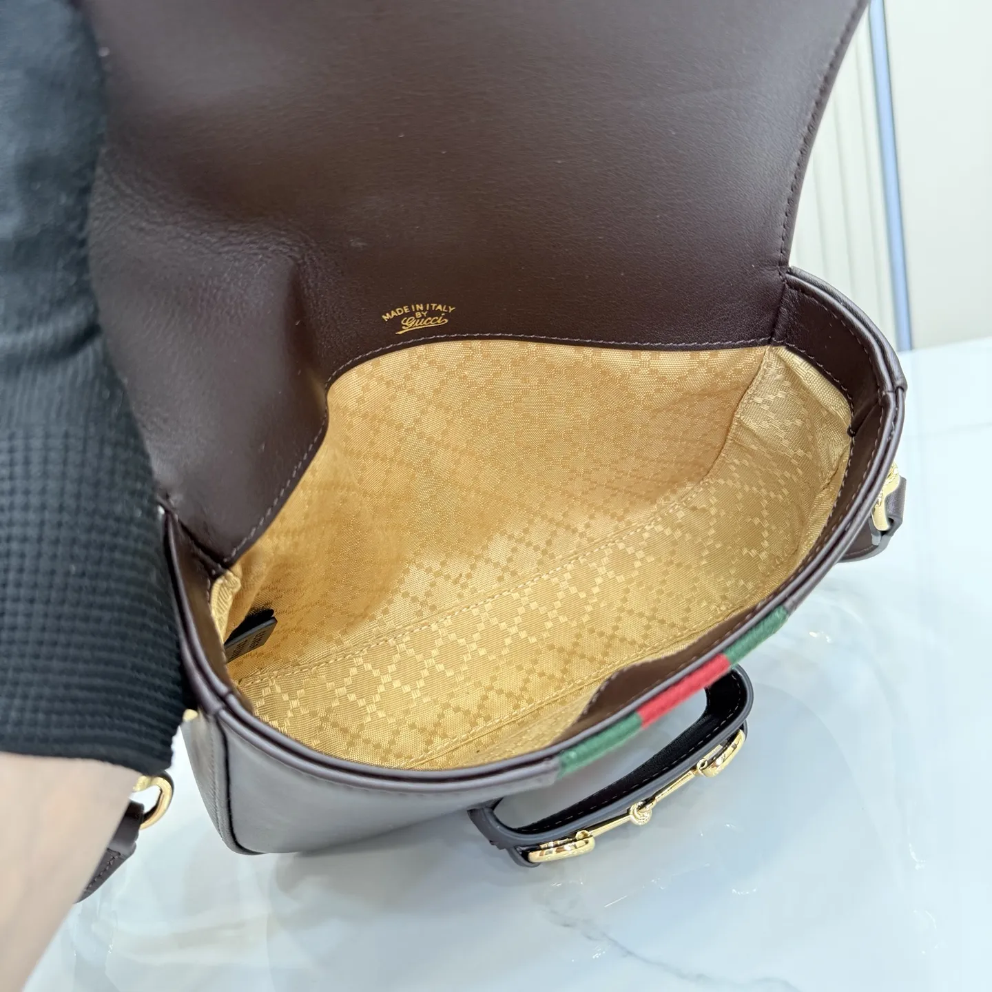 p660。【配全套专柜包装】‼️2026春夏系列全新上市。Gucci Horsebit 1955 系列包袋呈现柔韧雅致的廓形。此款式甄选柔软牛皮革打造,饰有Web织带细节,另配一条简约的可调节牛皮革肩带。 深棕色软皮 金色调配件 米色帆布衬里饰钻石菱格纹图案 马衔扣和织带 可拆卸和可调节牛皮革肩带,配搭扣,高:30厘米 翻盖开合 型号:866762。 尺寸:21厘米(宽)x 14.5厘米(高)x 5.5厘米(深) 重量:约0.5千克 颜色:深棕色/全皮。 意大利创作
