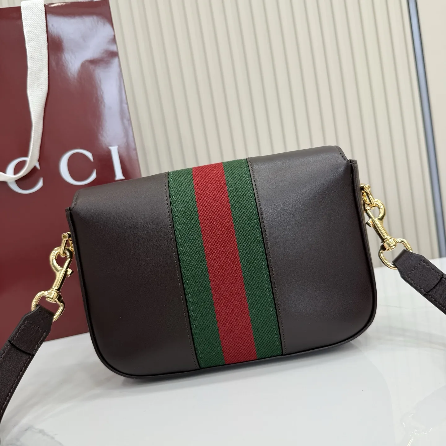 p660。【配全套专柜包装】‼️2026春夏系列全新上市。Gucci Horsebit 1955 系列包袋呈现柔韧雅致的廓形。此款式甄选柔软牛皮革打造，饰有Web织带细节，另配一条简约的可调节牛皮革肩带。 深棕色软皮 金色调配件 米色帆布衬里饰钻石菱格纹图案 马衔扣和织带 可拆卸和可调节牛皮革肩带，配搭扣，高：30厘米 翻盖开合 型号：866762。 尺寸：21厘米（宽）x 14.5厘米（高）x 5.5厘米（深） 重量：约0.5千克 颜色：深棕色/全皮。 意大利创作