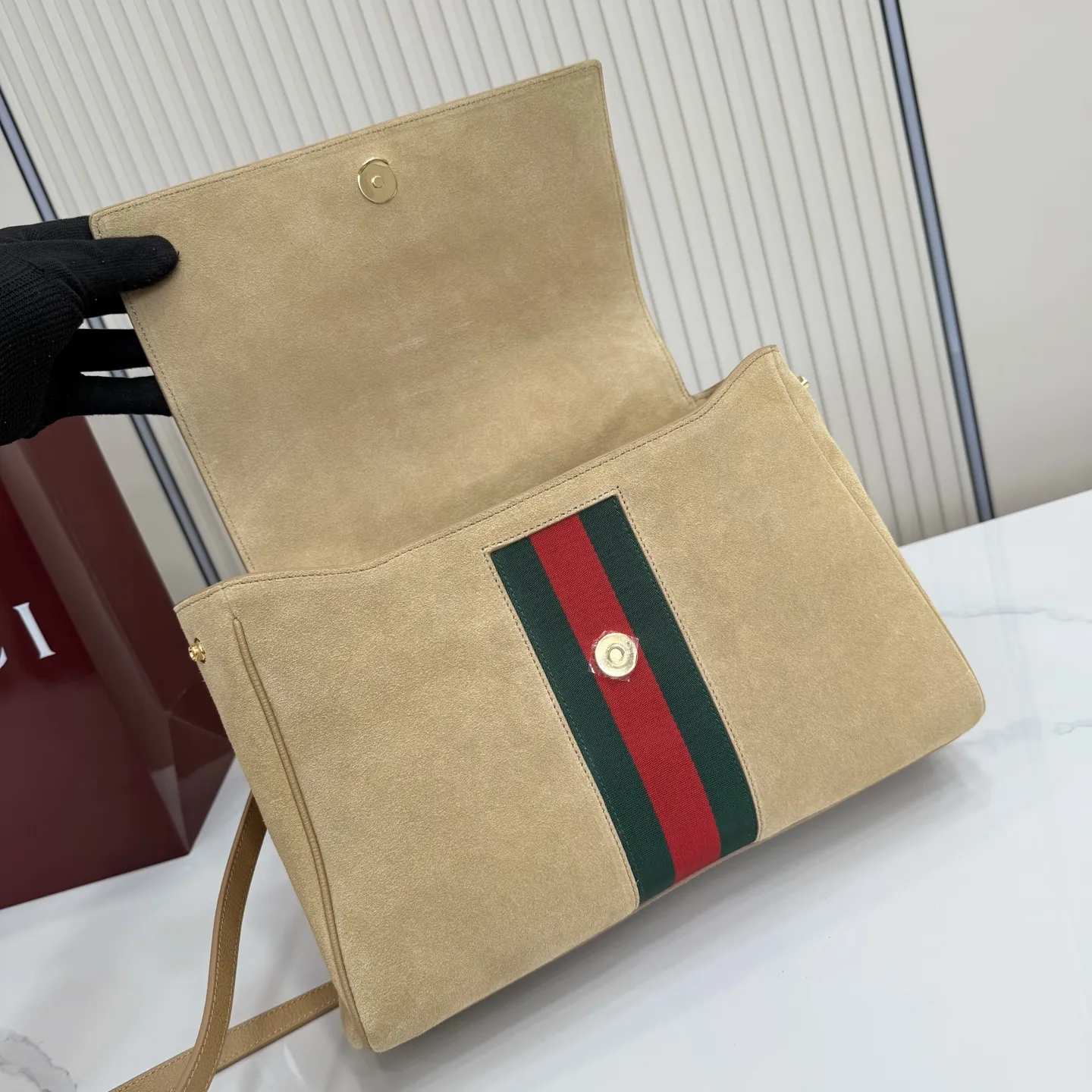 p710。【配全套包装】‼️Generation Gucci古驰世代系列深入探索品牌的典藏元素,将不同世代的设计融合为统一的美学叙事。这款款式以手提包设计向品牌标志性的马衔扣元素致敬,柔软的绒面皮革呈现精致的配色。 沙色柔软绒面材质 沙色皮革滚边 金色调配件 沙色帆布衬里,饰Diamante图案 马衔扣、织带和皮革标牌,带有“Made in Italy Gucci”标志 饰按扣 内部:1个拉链口袋,1个开口口袋 手柄垂直高度:17厘米 可拆卸和可调节皮革肩带下垂长度:42 - 54厘米;长度:93 - 112厘米 磁扣开合 型号:875018。 尺寸:30厘米(宽)x 21厘米(高)x 12厘米(深) 重量:约685克 颜色:杏色/绒皮。 意大利创作
