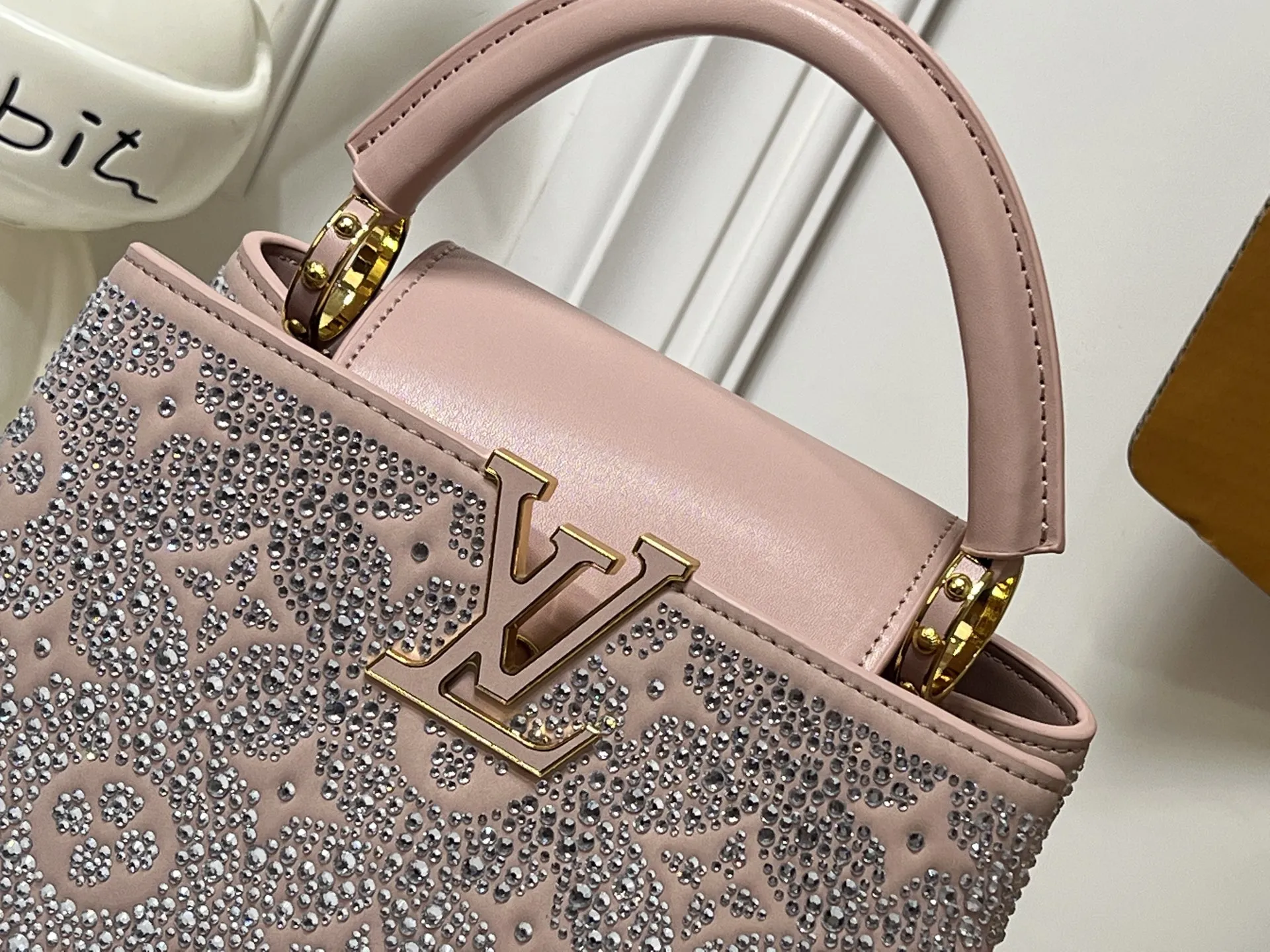 批205💰M27169 本款 LV Mirage 版 Capucines Nano 手袋出自 Exceptionals 系列，以丝缎 Taurillon 牛皮革成就晚宴佳选。Monogram 花卉闪烁仿水晶的璀璨光芒，金属 LV 字母续添瞩目华彩。内设贴袋和镜子，多重背携方式再现实用考量。尺寸27x 18x 9(厘米) ((长 x 高 x 宽)