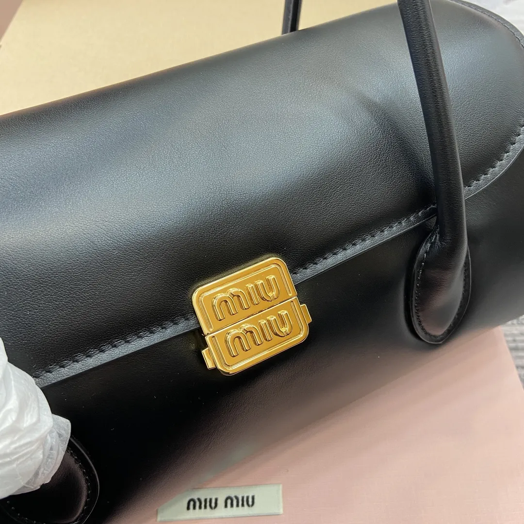 p900。【配全套专柜包装】‼️MIUMIU 24ss秋冬新款法棍包 法棍设计风格引领潮流新趋势，充满&rdquo;少女情怀&ldquo;围绕着书卷气展开，不羁且潇酒的大小姐风随意的人生态度，展现专属miumiu 女孩的独特，不大不小刚刚好的一只可甜辣可帅气 容量也满足日常出门所需好看又实用 很难不爱它诶！ 型号：5BD265。 28x11x15cm：28x11x15cm。 颜色：黑色全皮/原厂皮。