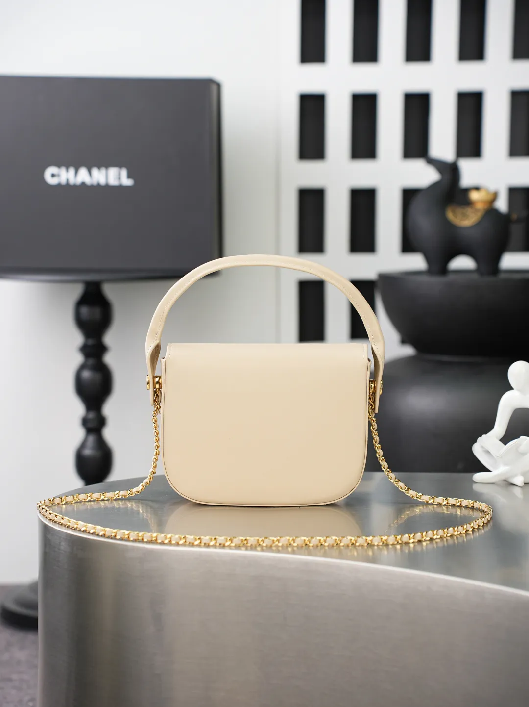 💼𝑪𝒉𝒂𝒏𝒆𝒍 𝟐𝟔𝑨 | 新品🆕手柄口盖包👜 💜独家背景💜实物实拍/顶级质量 ✨浅米色平滑光面小牛皮手提马鞍包🤍，细腻软糯的平纹牛皮搭配利落圆弧包身🌼，亮金色旋扣标识精致醒目，自带一体式同皮短提手，搭配可穿皮调节金属细链条，手提、斜挎两种背法随心切换，侧边皮扣细节做工工整，内里酒红色真皮衬里搭配金属刻印铭牌，走线细密均匀，柔和浅米色自带温婉日常氛围感☀️通勤约会各种穿搭都能轻松适配。 款号：6424 杏色牛皮 尺寸：𝟏𝟒.𝟓&times;𝟏𝟗.𝟓&times;𝟓𝒄𝒎