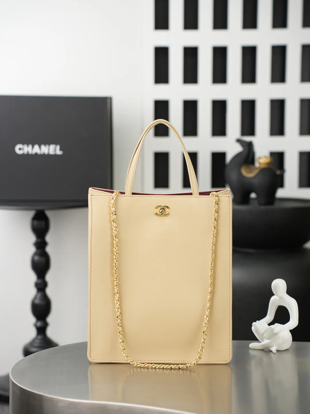 💼𝑪𝒉𝒂𝒏𝒆𝒍 𝟐𝟔𝑨 | 新款🆕高级手工坊👜 「图片小号」💜独家背景💜实物实拍/顶级质量 ✨奶茶光面小牛皮竖款托特包🤎，细腻平滑头层牛皮搭配利落方正包型🌼，亮金色旋扣标识精致醒目，搭配同皮短提手与可调节穿皮金属长链，手提斜挎两种背法随心切换，内里酒红色真皮内衬质感出众，磁吸按扣开合便捷，包身走线工整立体不易变形，底部平整支撑版型挺括，五金刻印清晰细腻，柔和浅奶茶色调自带温婉通勤氛围感☀️，日常通勤、逛街出行都十分适配。 款号：6452 颜色如图所示💝带包装盒 尺寸：𝟐𝟖.𝟓&times;𝟐𝟑.𝟓&times;𝟗.𝟓𝒄𝒎