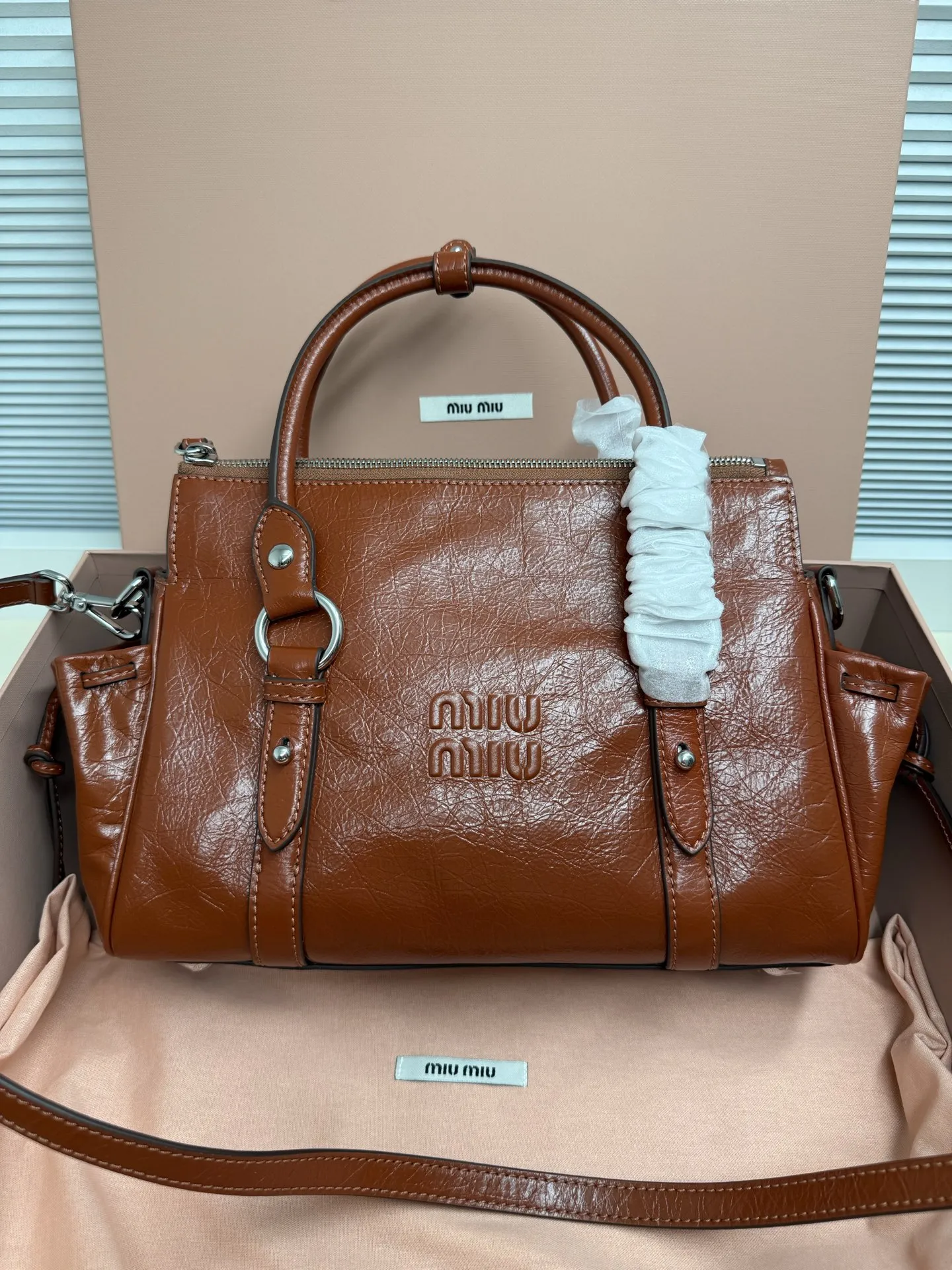 Miumiu26早春新款油蜡皮机车包 这款是油蜡牛皮的、 国内上的是蝴蝶结 版的 欧洲这款把蝴蝶结改成了褶皱抽绳 有长肩带可以斜挎，尺寸 小号29*15*13cm 款号333