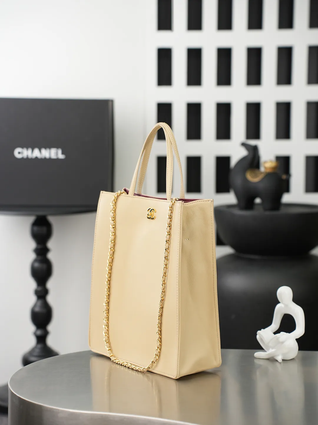 💼𝑪𝒉𝒂𝒏𝒆𝒍 𝟐𝟔𝑨 | 新款🆕高级手工坊👜 「图片小号」💜独家背景💜实物实拍/顶级质量 ✨奶茶光面小牛皮竖款托特包🤎，细腻平滑头层牛皮搭配利落方正包型🌼，亮金色旋扣标识精致醒目，搭配同皮短提手与可调节穿皮金属长链，手提斜挎两种背法随心切换，内里酒红色真皮内衬质感出众，磁吸按扣开合便捷，包身走线工整立体不易变形，底部平整支撑版型挺括，五金刻印清晰细腻，柔和浅奶茶色调自带温婉通勤氛围感☀️，日常通勤、逛街出行都十分适配。 款号：6452 颜色如图所示💝带包装盒 尺寸：𝟐𝟖.𝟓&times;𝟐𝟑.𝟓&times;𝟗.𝟓𝒄𝒎