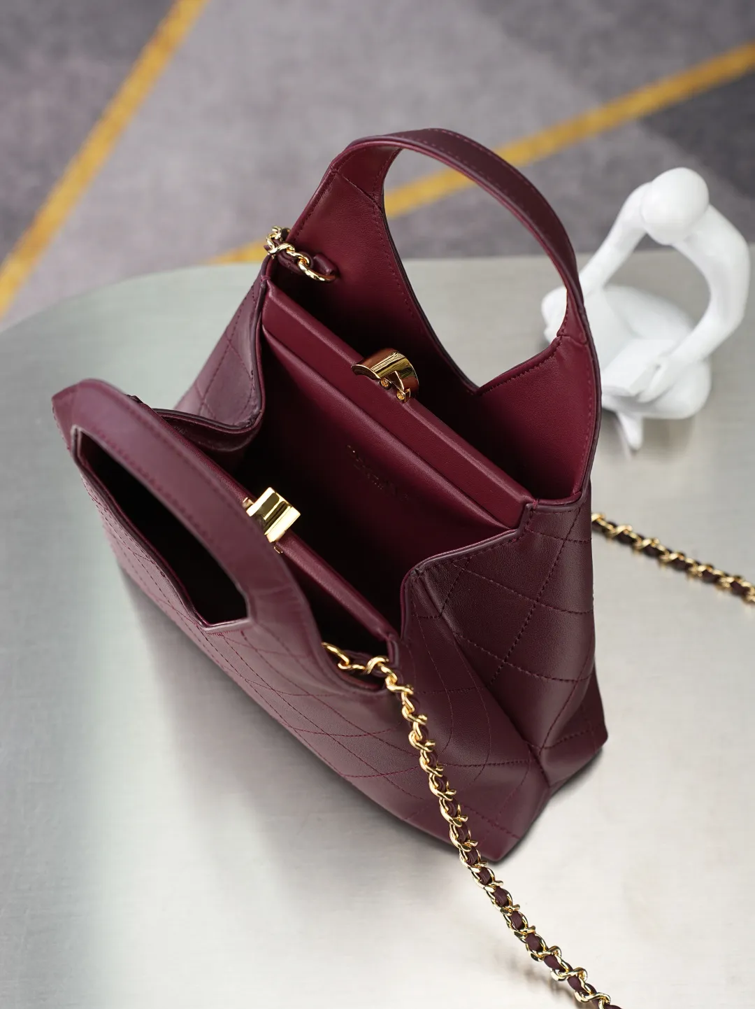 💼𝑪𝒉𝒂𝒏𝒆𝒍 𝟐𝟔𝑨 | 高级手工坊系列👜 💜独家背景💜实物实拍/顶级质量 ✨酒红色小羊皮手提小包🍷，细腻平滑羊皮搭配规整菱格绗缝🌼，亮金色双C锁扣精致大气，自带一体手提柄，还配有穿皮金属链条，手提斜挎两种背法随心切换，包身三角造型柔和饱满，内衬同色系真皮，五金刻印清晰细腻，浓郁复古红自带氛围感☀️，日常出行、约会通勤都很适配。 款号：6392 酒红色牛皮/金扣 尺寸：𝟐𝟑&times;𝟐𝟑&times;𝟕𝒄𝒎/带包装盒