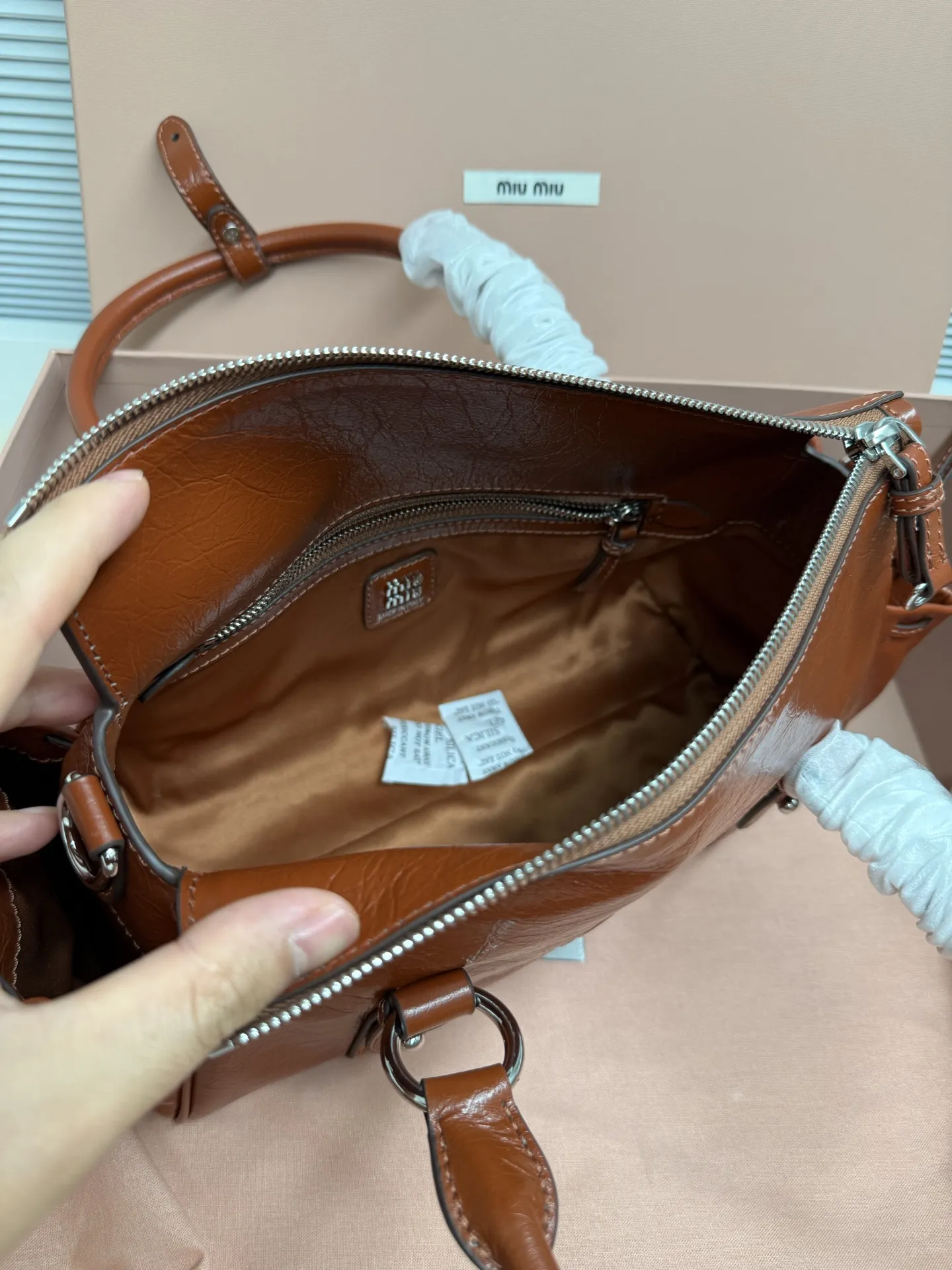 Miumiu26早春新款油蜡皮机车包 这款是油蜡牛皮的、 国内上的是蝴蝶结 版的 欧洲这款把蝴蝶结改成了褶皱抽绳 有长肩带可以斜挎，尺寸 小号29*15*13cm 款号333