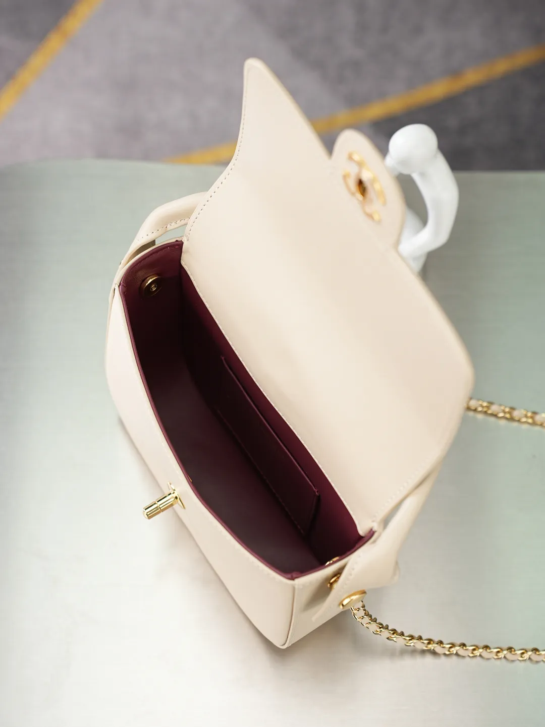 💼𝑪𝒉𝒂𝒏𝒆𝒍 𝟐𝟔𝑨 | 新品🆕手柄口盖包👜 💜独家背景💜实物实拍/顶级质量 ✨浅米色平滑光面小牛皮手提马鞍包🤍,细腻软糯的平纹牛皮搭配利落圆弧包身🌼,亮金色旋扣标识精致醒目,自带一体式同皮短提手,搭配可穿皮调节金属细链条,手提、斜挎两种背法随心切换,侧边皮扣细节做工工整,内里酒红色真皮衬里搭配金属刻印铭牌,走线细密均匀,柔和浅米色自带温婉日常氛围感☀️通勤约会各种穿搭都能轻松适配。 款号:6424 杏色牛皮 尺寸:𝟏𝟒.𝟓×𝟏𝟗.𝟓×𝟓𝒄𝒎