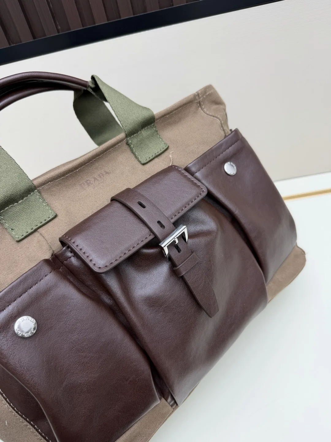 批 210💰👜Prada 春夏Route系列多口袋帆布包，军旅风设计超有型！卡其帆布+棕色皮革拼接，质感满分✨。正面多口袋，按扣&搭扣超实用，收纳力强，通勤or短途旅行都很适合。配可调节肩带，手提斜挎都OK，男女都能轻松驾驭，时尚又百搭！ 尺寸35-24-15，型号2633