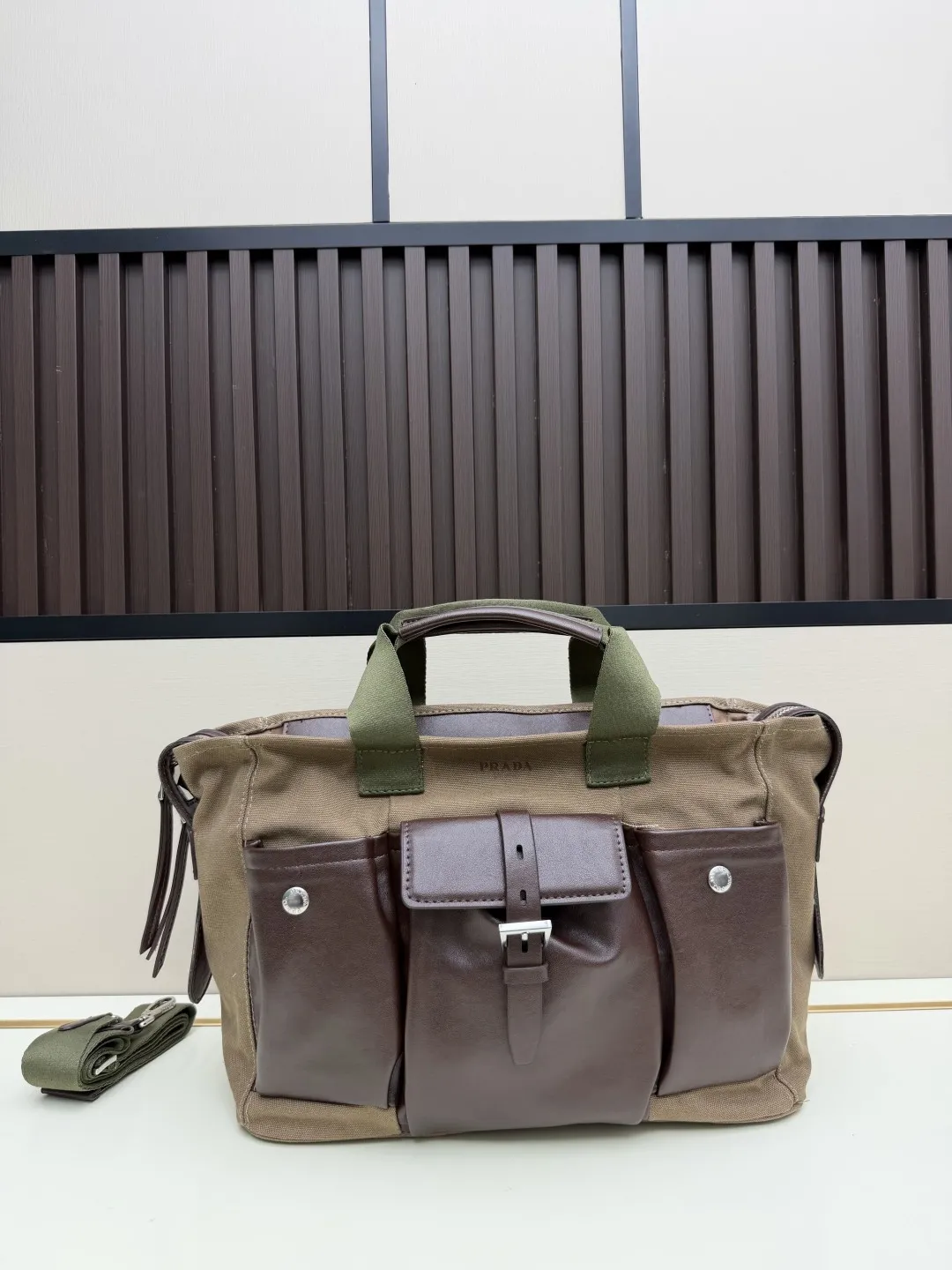 批 210💰👜Prada 春夏Route系列多口袋帆布包，军旅风设计超有型！卡其帆布+棕色皮革拼接，质感满分✨。正面多口袋，按扣&搭扣超实用，收纳力强，通勤or短途旅行都很适合。配可调节肩带，手提斜挎都OK，男女都能轻松驾驭，时尚又百搭！ 尺寸35-24-15，型号2633