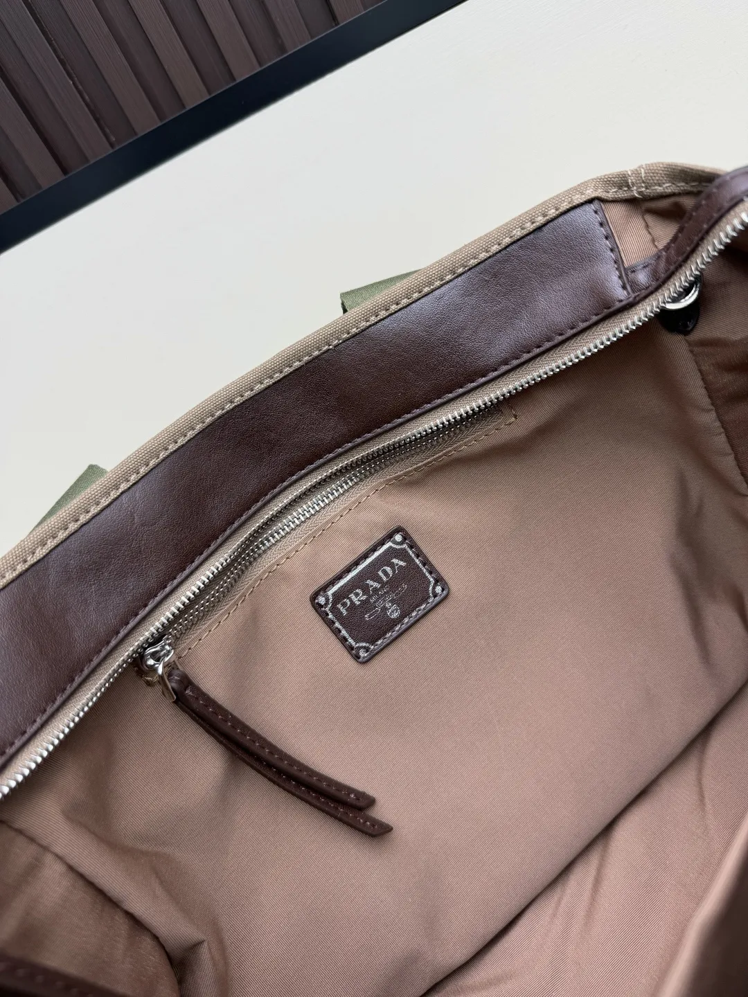 批 210💰👜Prada 春夏Route系列多口袋帆布包，军旅风设计超有型！卡其帆布+棕色皮革拼接，质感满分✨。正面多口袋，按扣&搭扣超实用，收纳力强，通勤or短途旅行都很适合。配可调节肩带，手提斜挎都OK，男女都能轻松驾驭，时尚又百搭！ 尺寸35-24-15，型号2633