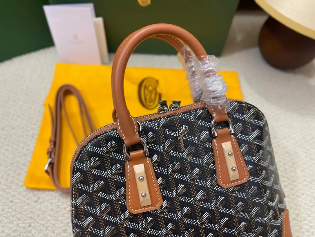 Goyard(戈雅)最新款vendome贝壳包上新,传承了品牌独一无二的工艺风格和精湛技术:可折叠肩带、嵌入木质细节、皮革包角、大拉链、黄色衬里及其独特的贝壳形状,可满足手提或置于手臂弯曲处两种经典背法,还附加了精巧的肩带,更为贴合当代都市风格,以适应单肩或挎的用法,尺寸:底长23cm宽10.5高18.5 P580