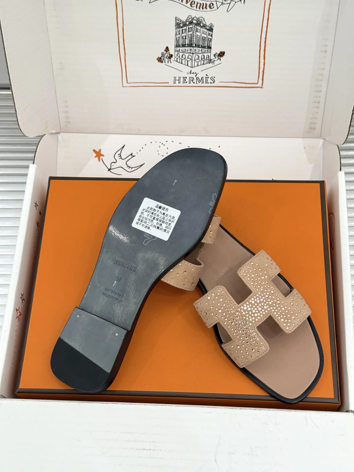 厂价💰320（配原版飞机盒） Herm&egrave;s/爱马仕经典H拖鞋 夏日H拖天花板 H家出品质感封神 标志性H型镂空鞋面 简约线条藏着品牌的底蕴 平底款随性又好搭 粗跟款悄悄拉长腿型比例 金棕配色最经典 黑色百搭不挑人不出错 配牛仔自带松弛感 搭连衣裙秒变温柔大小姐 通勤度假都适配 一脚蹬出门省心又时髦 老钱风氛围拉满 鞋柜常青款值得闭眼投资 夏日穿搭灵魂单品 上脚才懂什么叫质感绝了 轻奢好物闭眼入 承包整夏的精致与舒适感 意大利手工匠造 细节处见品牌的用心 越穿越有复古韵味 是能穿好几年的经典款！ 面料采用原版定制真丝 内里踮脚均为羊皮 意大利进口真皮大底 size：35-39（40/41定制） 编号：96820260713