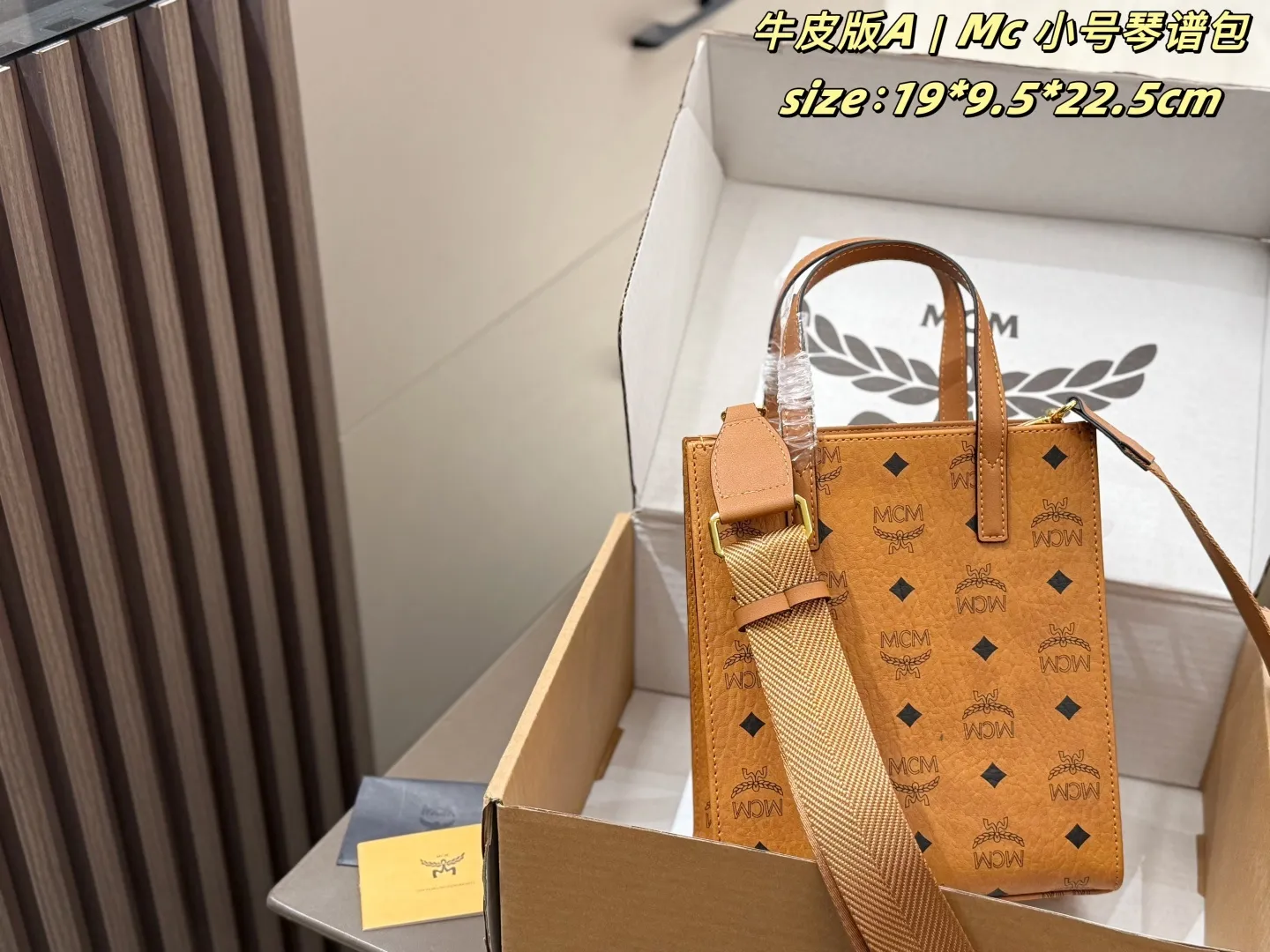 P140 牛皮 配盒 Mc 小号琴谱包 MCM小号琴谱托特包,经典干邑色老花满印,牛皮材质,方形金属铭牌五金。配备手提柄+宽织纹肩带,可手提、单肩、斜挎,版型挺括,日常通勤收纳能力强,复古百搭。 size:19*9.5*22.5cm