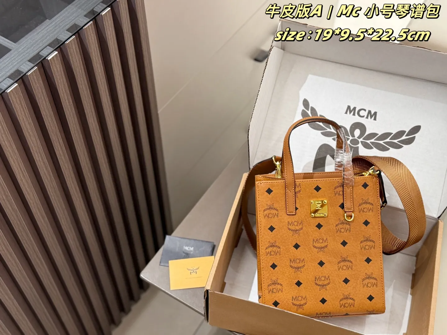 P140 牛皮 配盒 Mc 小号琴谱包 MCM小号琴谱托特包，经典干邑色老花满印，牛皮材质，方形金属铭牌五金。配备手提柄+宽织纹肩带，可手提、单肩、斜挎，版型挺括，日常通勤收纳能力强，复古百搭。 size：19*9.5*22.5cm