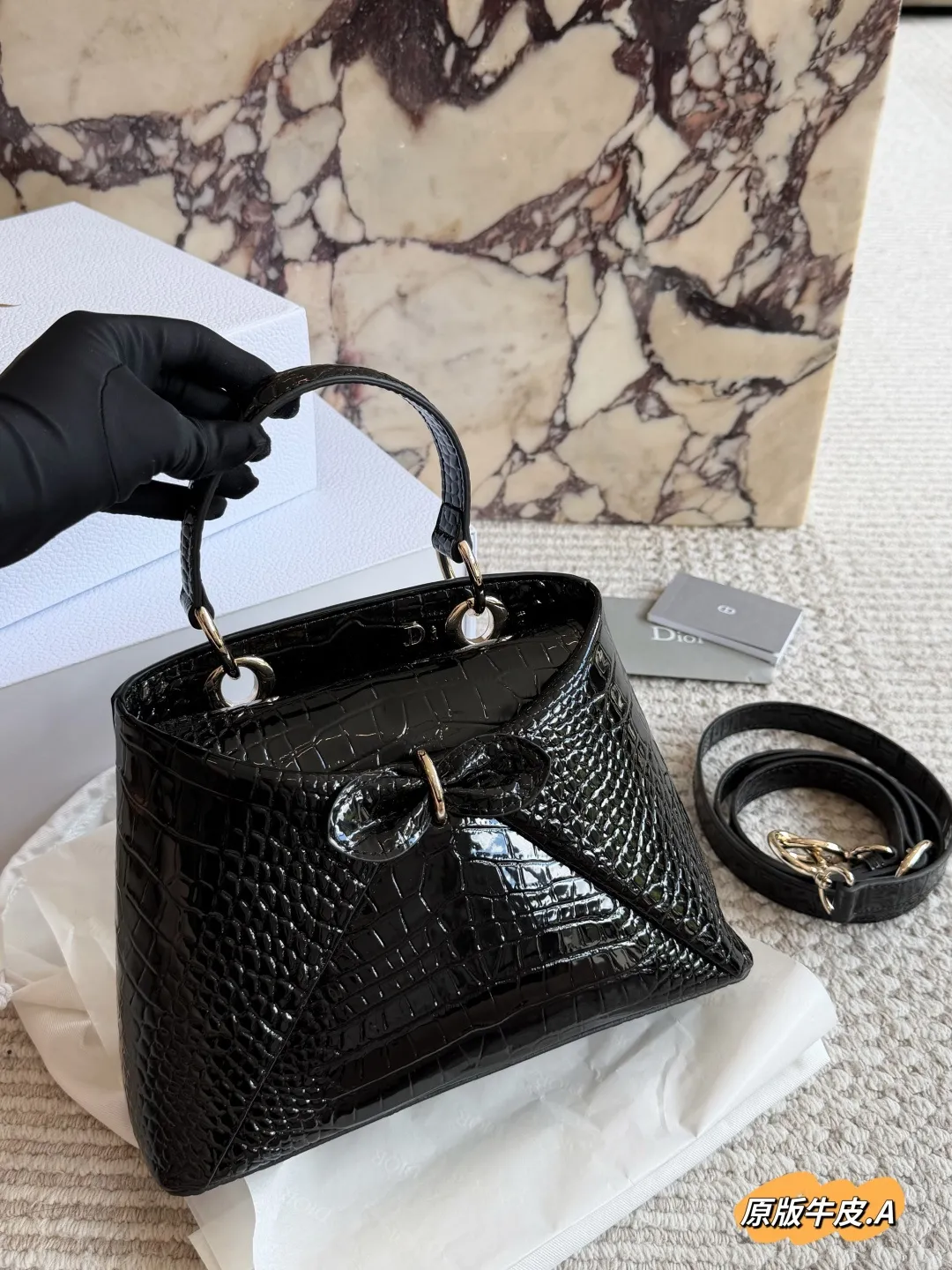 p275 Dior 2026春夏蝴蝶结手提包 原版牛皮 Dior 2026春夏蝴蝶结手提包由Jonathan Anderson设计，灵感来自品牌典藏元素。黑色皮革材质，正面立体蝴蝶结+金属扣，优雅又有辨识度+。手柄融入&ldquo;Dior&rdquo;字母，细节满分!尺寸适中，手提or肩背都OK，通勤、正式场合都能轻松驾驭。建筑感廓形+现代美学，时尚实用兼备，是本季超亮眼单品!，25cm配盒子