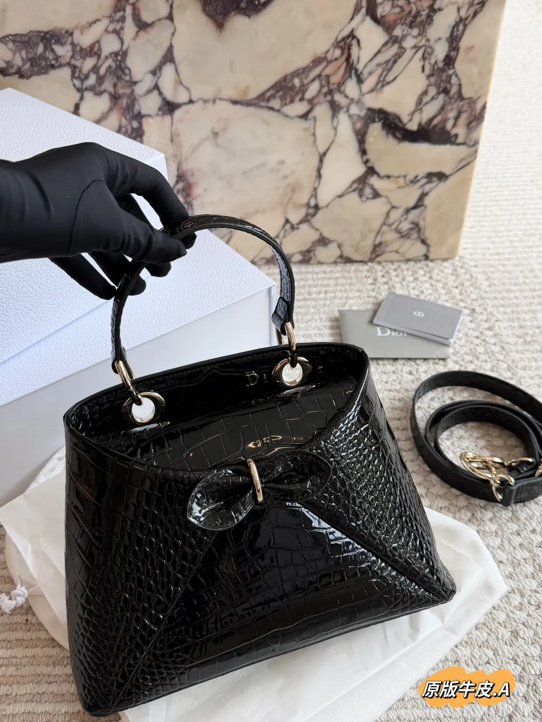 p275 Dior 2026春夏蝴蝶结手提包 原版牛皮 Dior 2026春夏蝴蝶结手提包由Jonathan Anderson设计,灵感来自品牌典藏元素。黑色皮革材质,正面立体蝴蝶结+金属扣,优雅又有辨识度+。手柄融入“Dior”字母,细节满分!尺寸适中,手提or肩背都OK,通勤、正式场合都能轻松驾驭。建筑感廓形+现代美学,时尚实用兼备,是本季超亮眼单品!,25cm配盒子